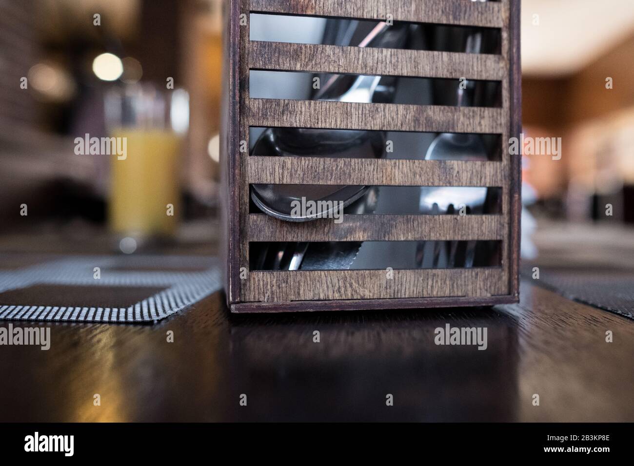 Holzbestecke stehen in einem Café. Löffel, Gabel zum Mittagessen in einem Restaurant. Brauner Hintergrund Stockfoto