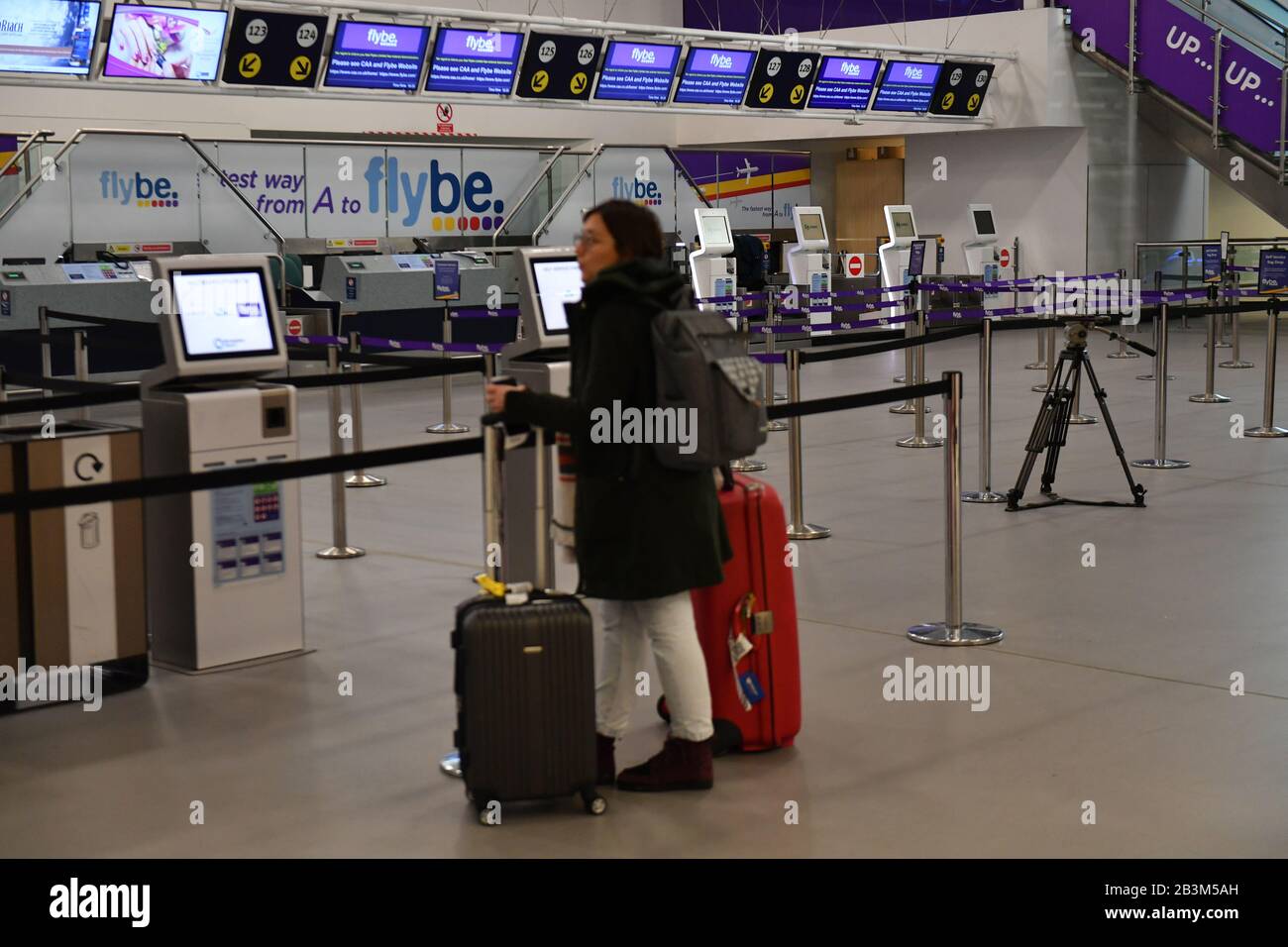 Ein Passagier betrachtet leere Check-In-Schalter am internationalen Flughafen von Birmingham, da Flybe, Europas größte regionale Fluggesellschaft, in die Verwaltung eingebrochen ist. Stockfoto