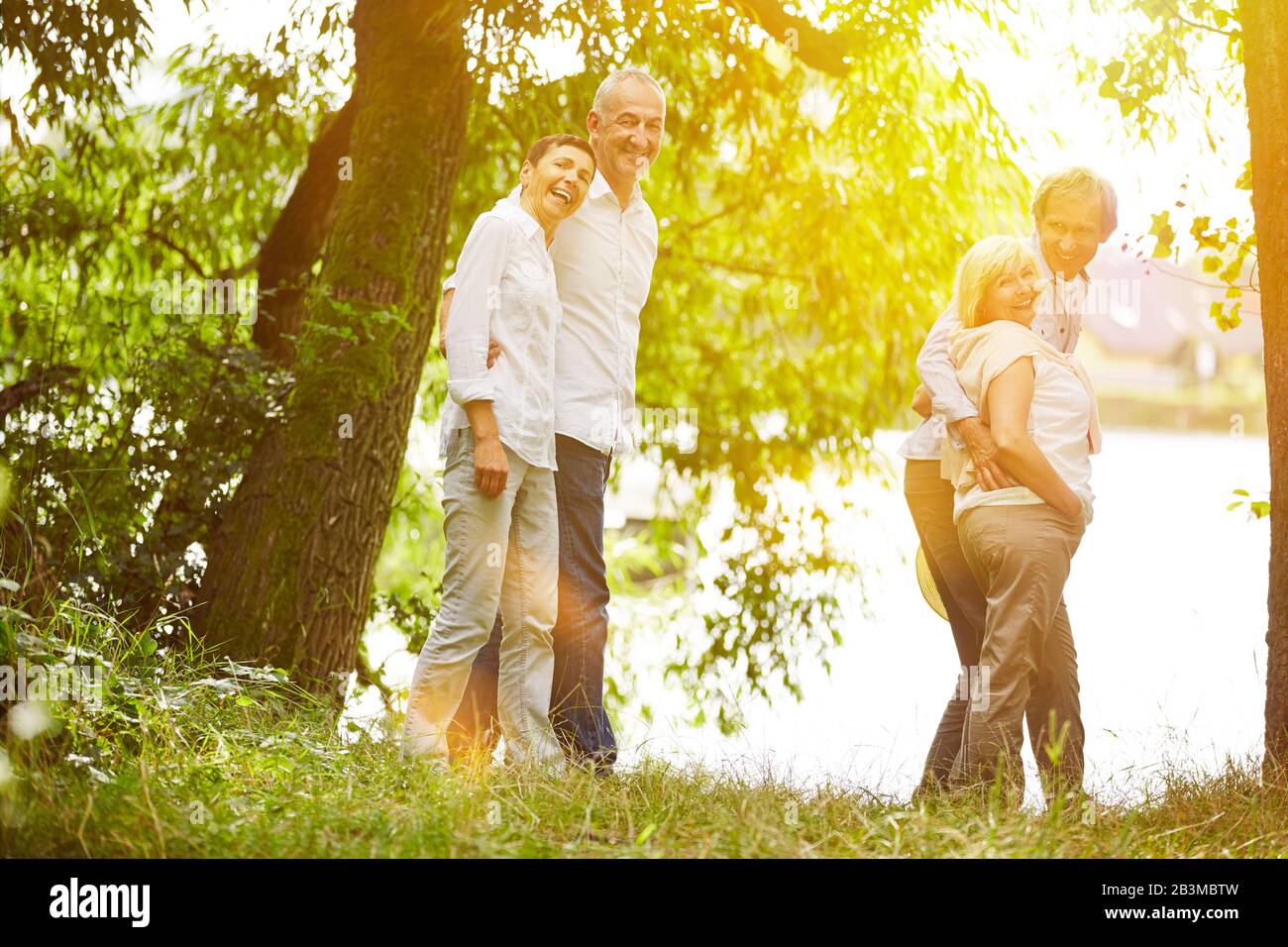 Lachende Senioren gehen im Sommer gemeinsam auf eine Reise Stockfoto