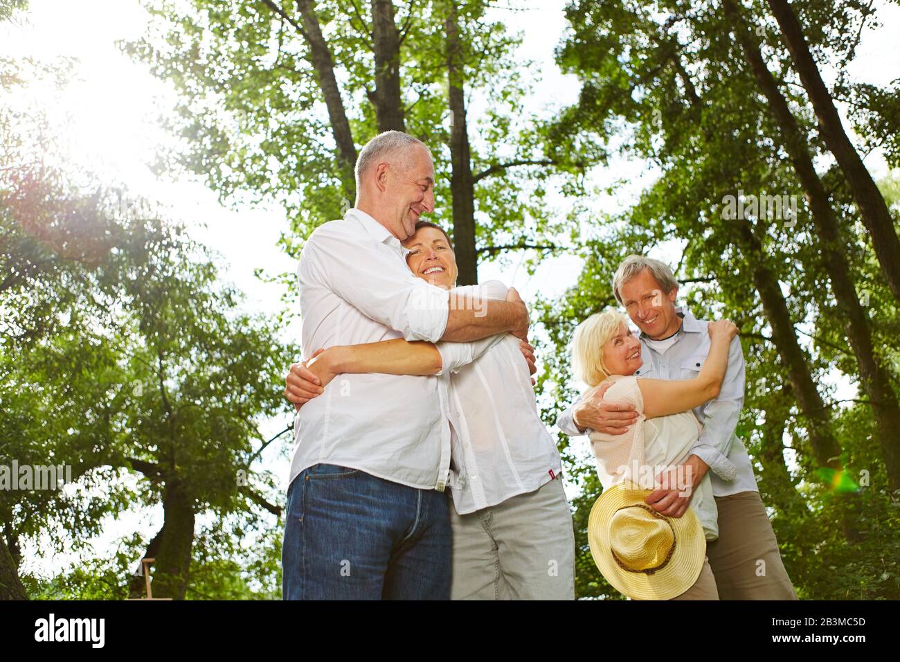 Zwei glückliche Paare von Senioren umarmen sich in die Natur Stockfoto