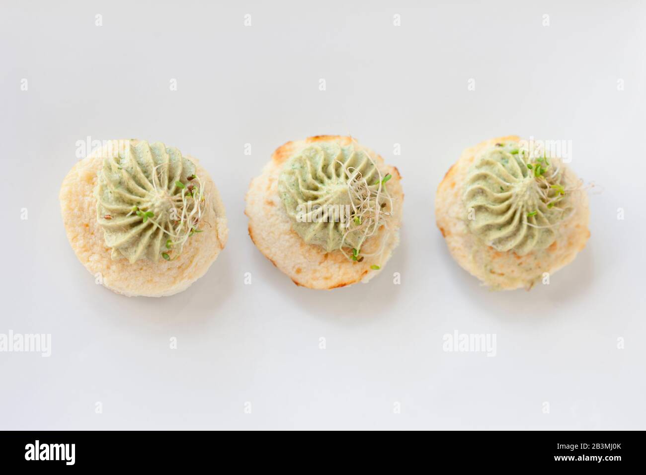 Mini-Blumenkohl-Aufläufe mit Avocado-Creme auf einem weißen Teller Stockfoto