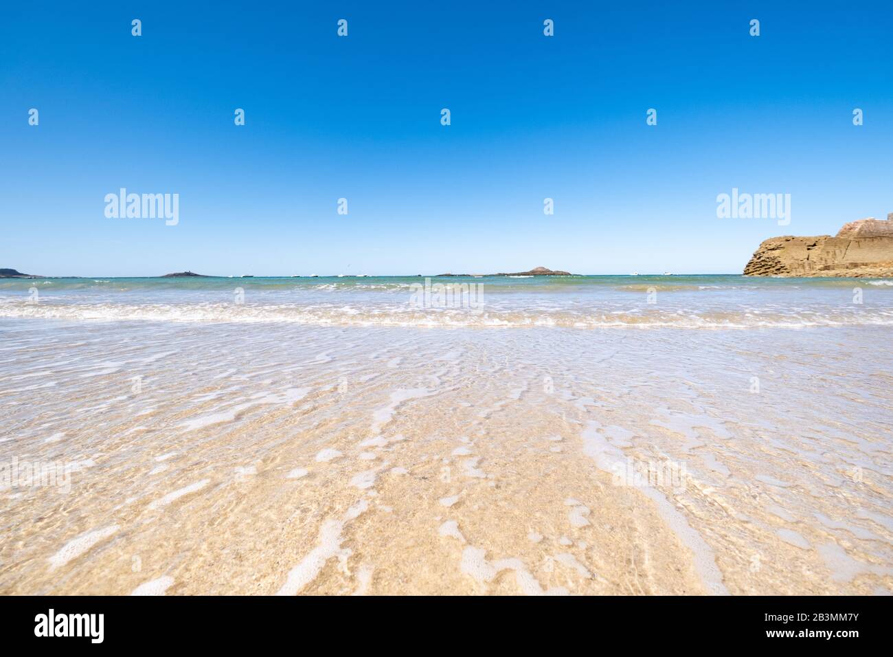 Großer Strand in der Stadt Sables d'Or les Pins in der Bretagne bei Ebbe im Sommer. Stockfoto