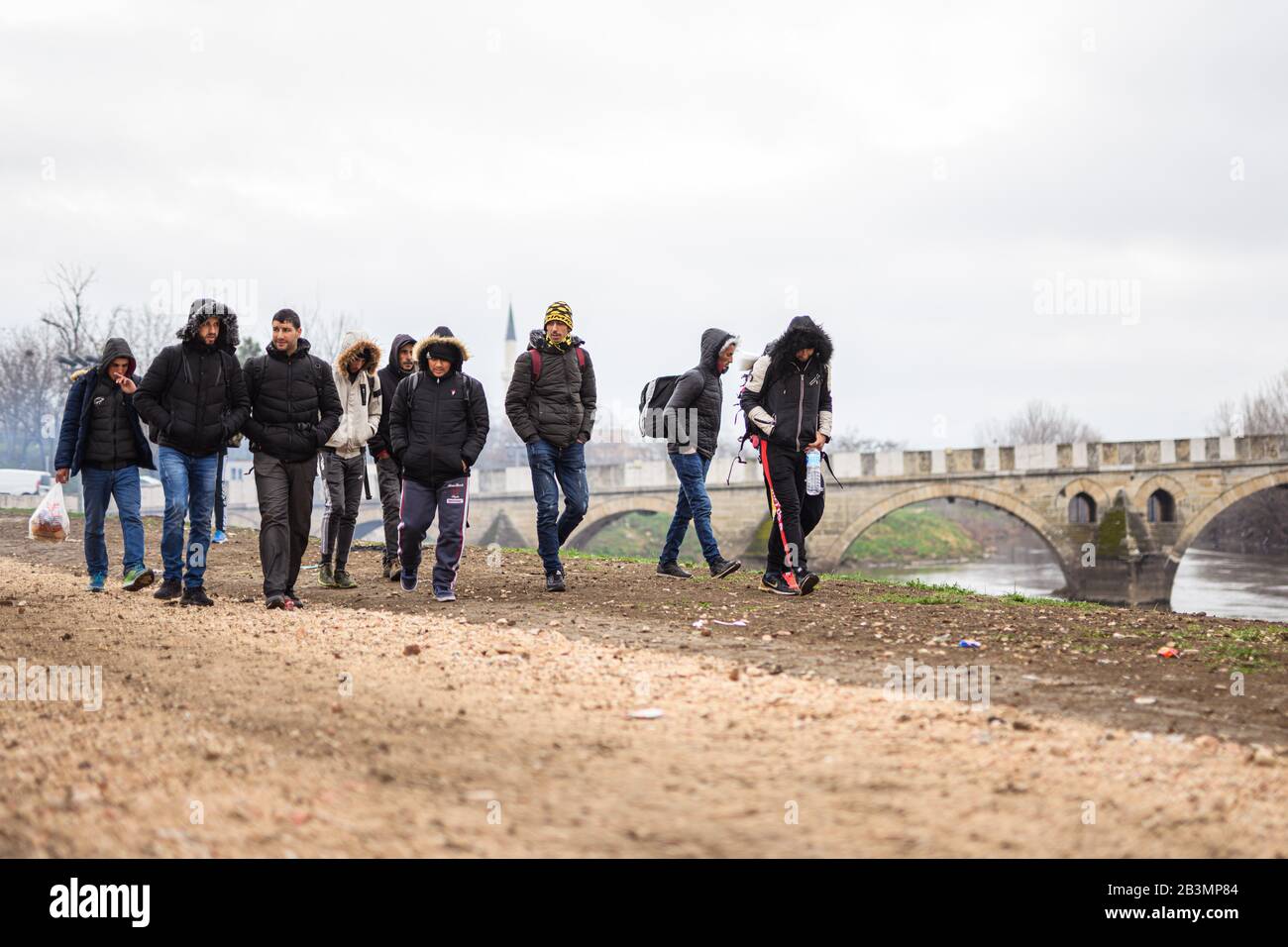 Edirne, Türkei. März 2020. Syrische Flüchtlinge wandern entlang des Flusses "Tunca Nehri" nahe dem Grenzübergang Pazarkule-Kastanies in der türkischen Grenzstadt Edirne. Kredit: Mohssen Assanimoghaddam / dpa / Alamy Live News Stockfoto