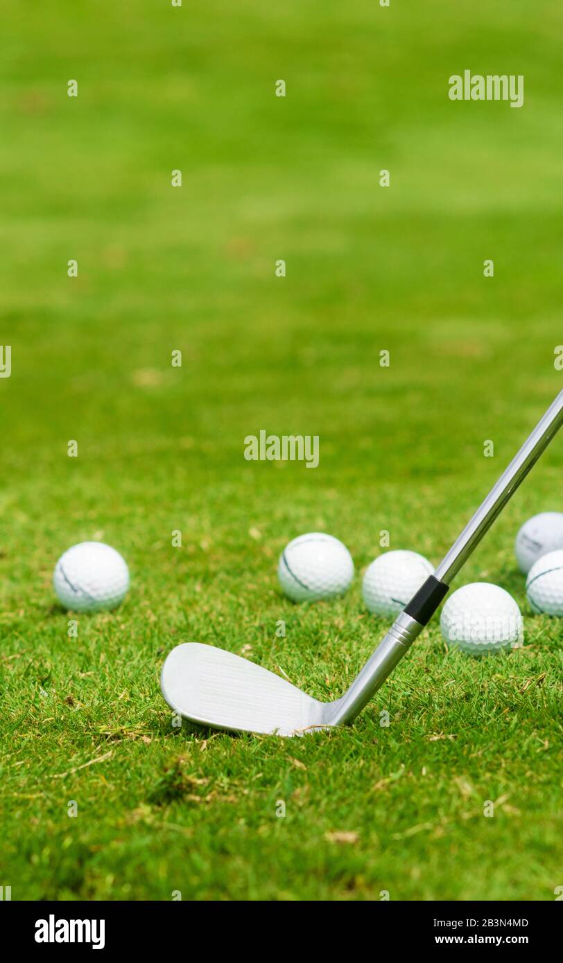 Golfeisen und Kugeln im vertikalen Kopierraum des Grases Stockfoto