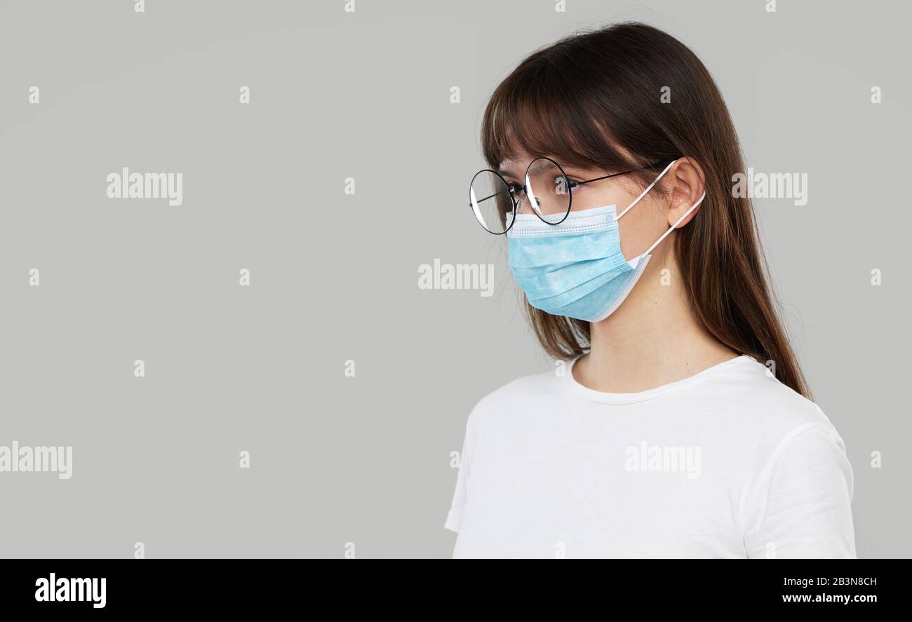 Asian Woman fühlt sich unwohl und trägt Gesichtsschutzmaske auf grauem Studiohintergrund. Platz für Text kopieren. Die erste Verteidigung gegen die Epidemie von Stockfoto