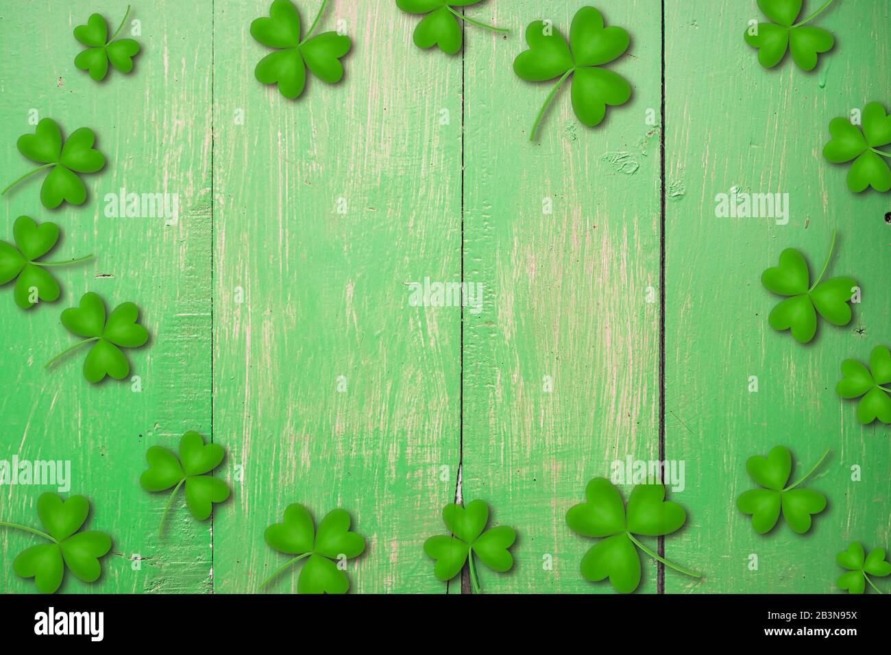 Shamrocks auf grünem Holztisch ein Symbol und St. Patricks Day. Bbanner mit Eckrand von Shamrocks. Strukturiertes Muster Stockfoto