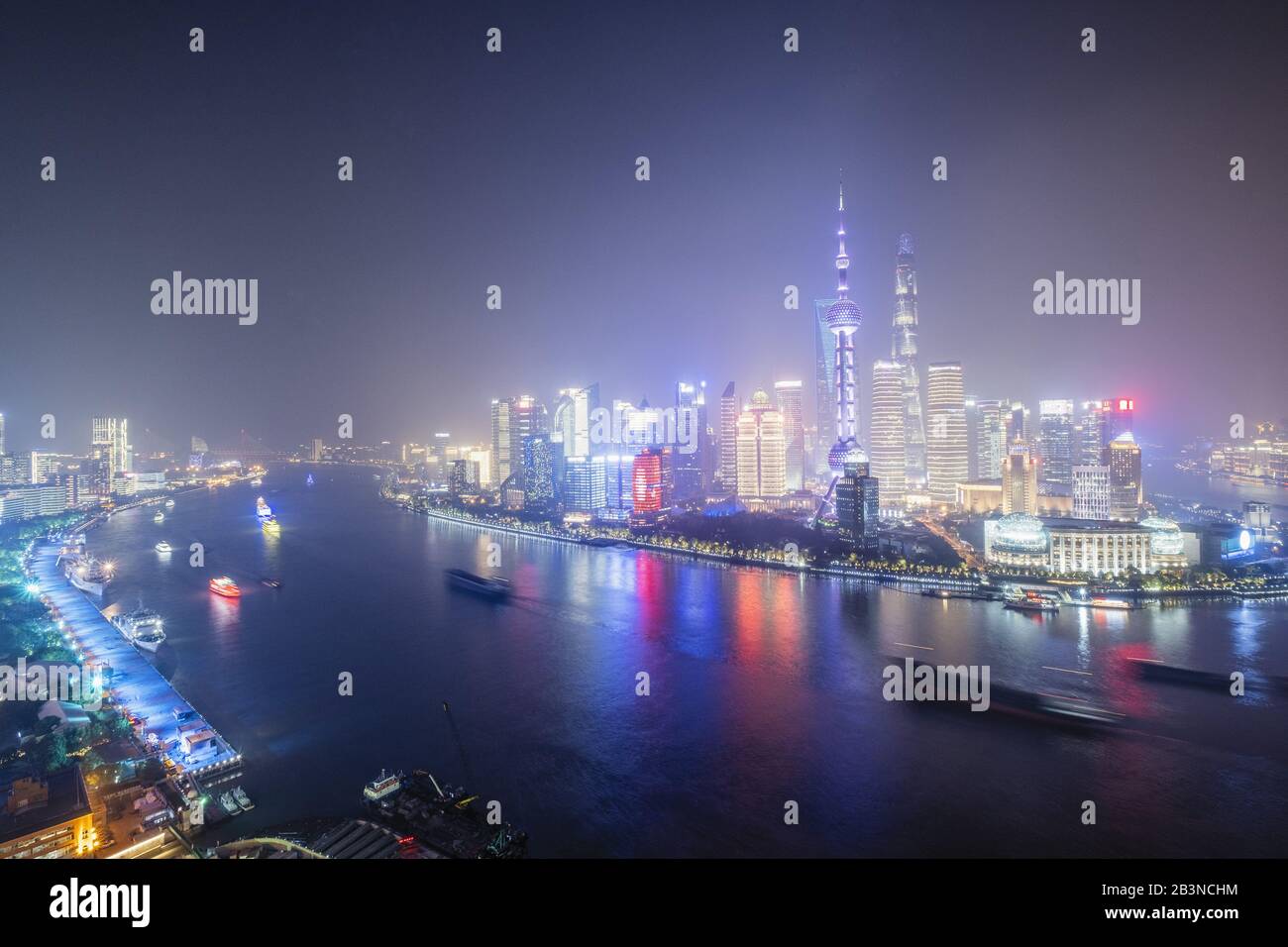 Die beleuchtete Skyline des Pudong Viertels in Shanghai mit dem Huangpu Fluss im Vordergrund, Shanghai, China, Asien Stockfoto