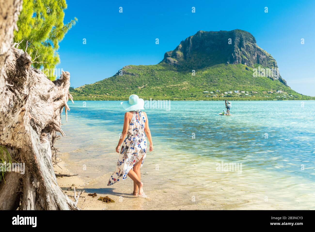 Frau am tropischen Strand mit Blick auf Paddleboard in der Lagune, La Gaulette, Le Morne brabant, Black River, Mauritius, Indischer Ozean, Afrika Stockfoto