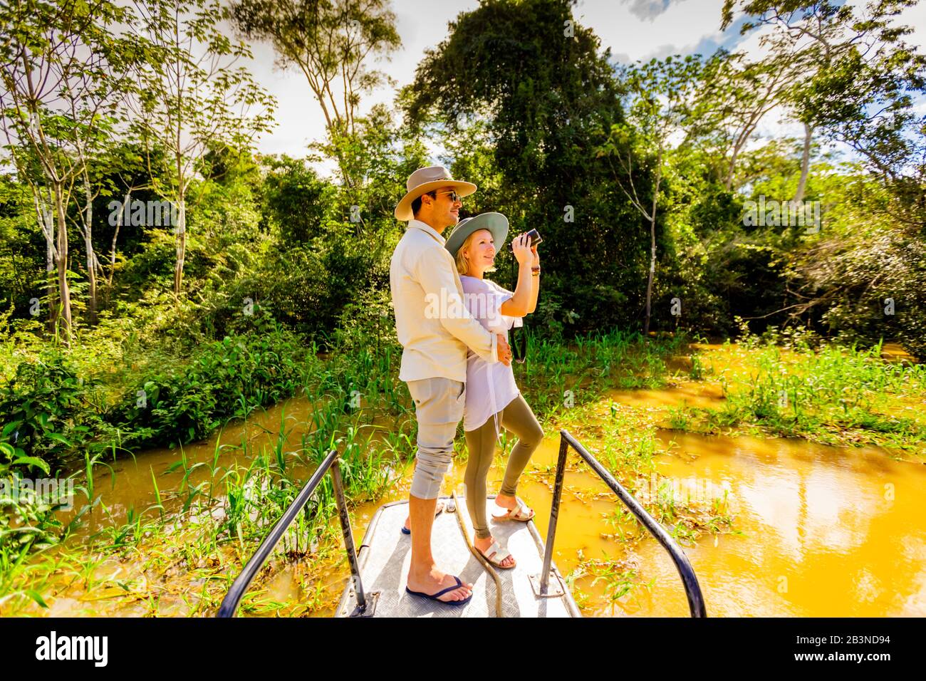 Paare, die auf einer Bootstour durch den Amazonas-Fluss, Peru, Südamerika nach Wildtieren suchen Stockfoto