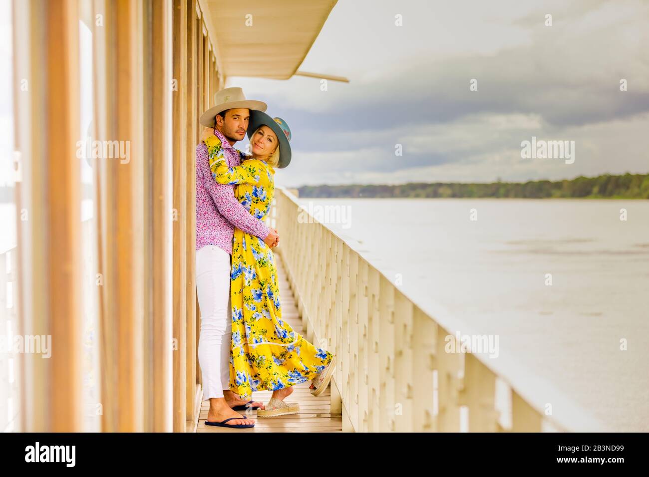 Ein Paar posiert für die Kamera mit Blick auf den Amazonas-Fluss an Bord eines Flussboots, Peru, Südamerika Stockfoto