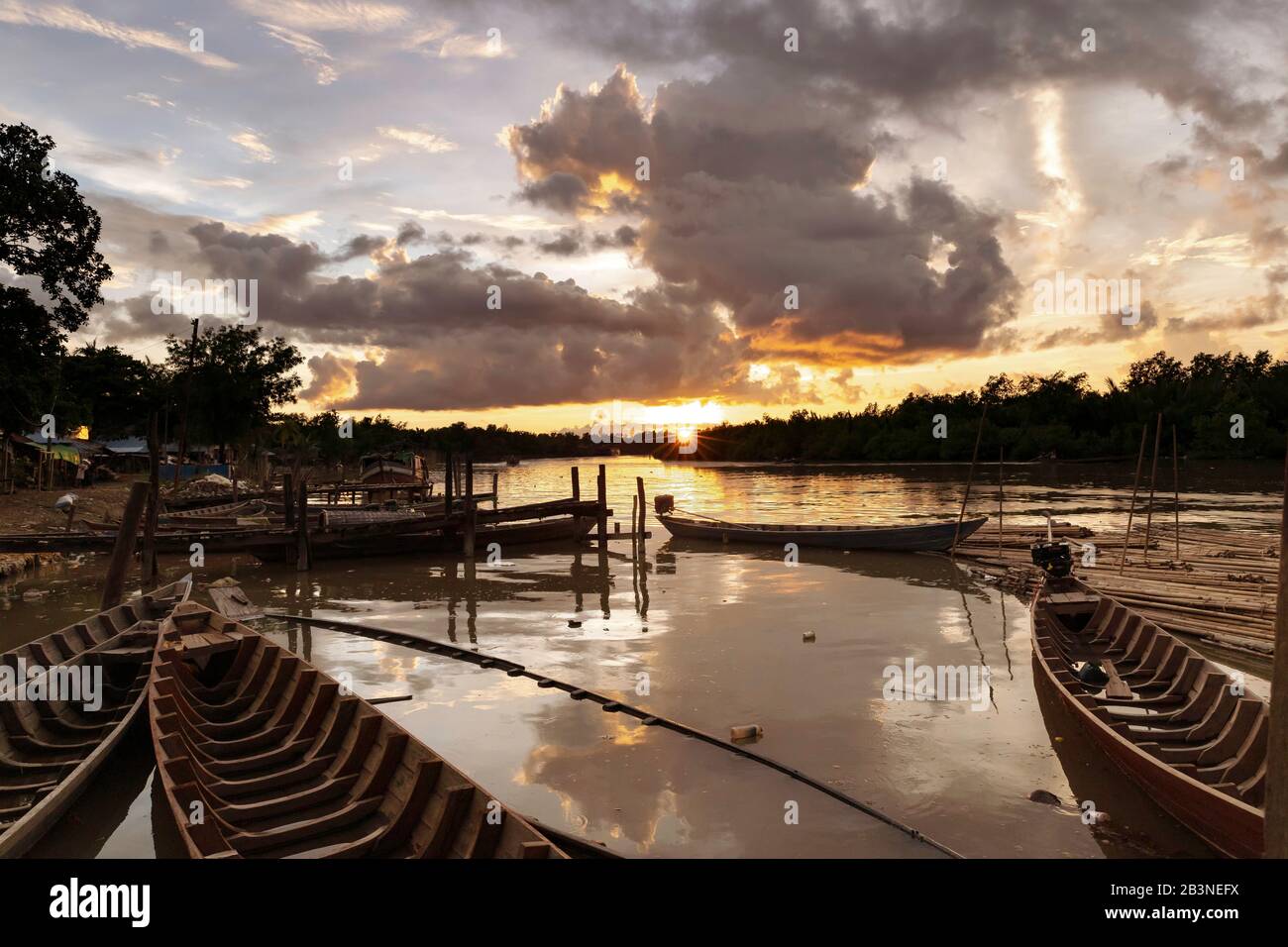 Mrauk U Bootsanlegesteg bei Sonnenuntergang mit wasserprotokollierten Kanus im Vordergrund, Mrauk U, Rakhine, Myanmar (Birma), Asien Stockfoto