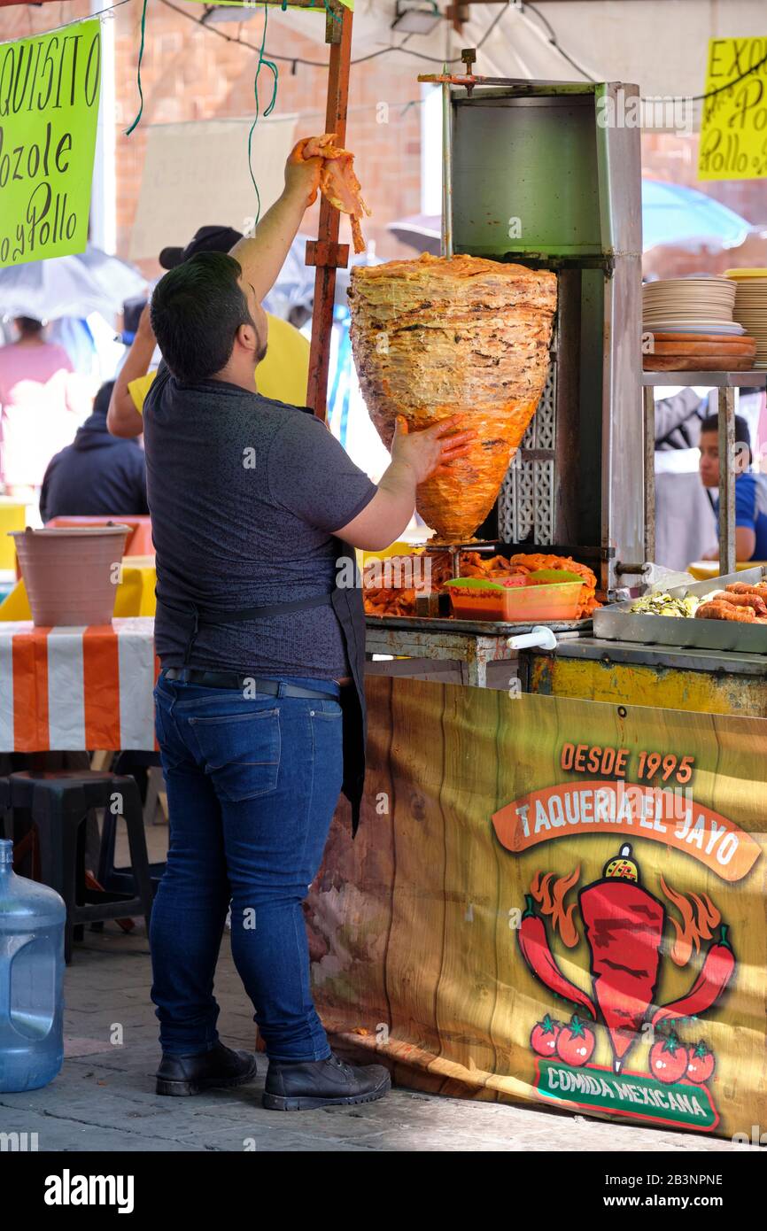 Mann, der Hühnerpastor marinade auf einem Spieß in der mexikanischen Outdoor-Küche Karre taqueria auf der Karnevalsmesse organisiert Stockfoto