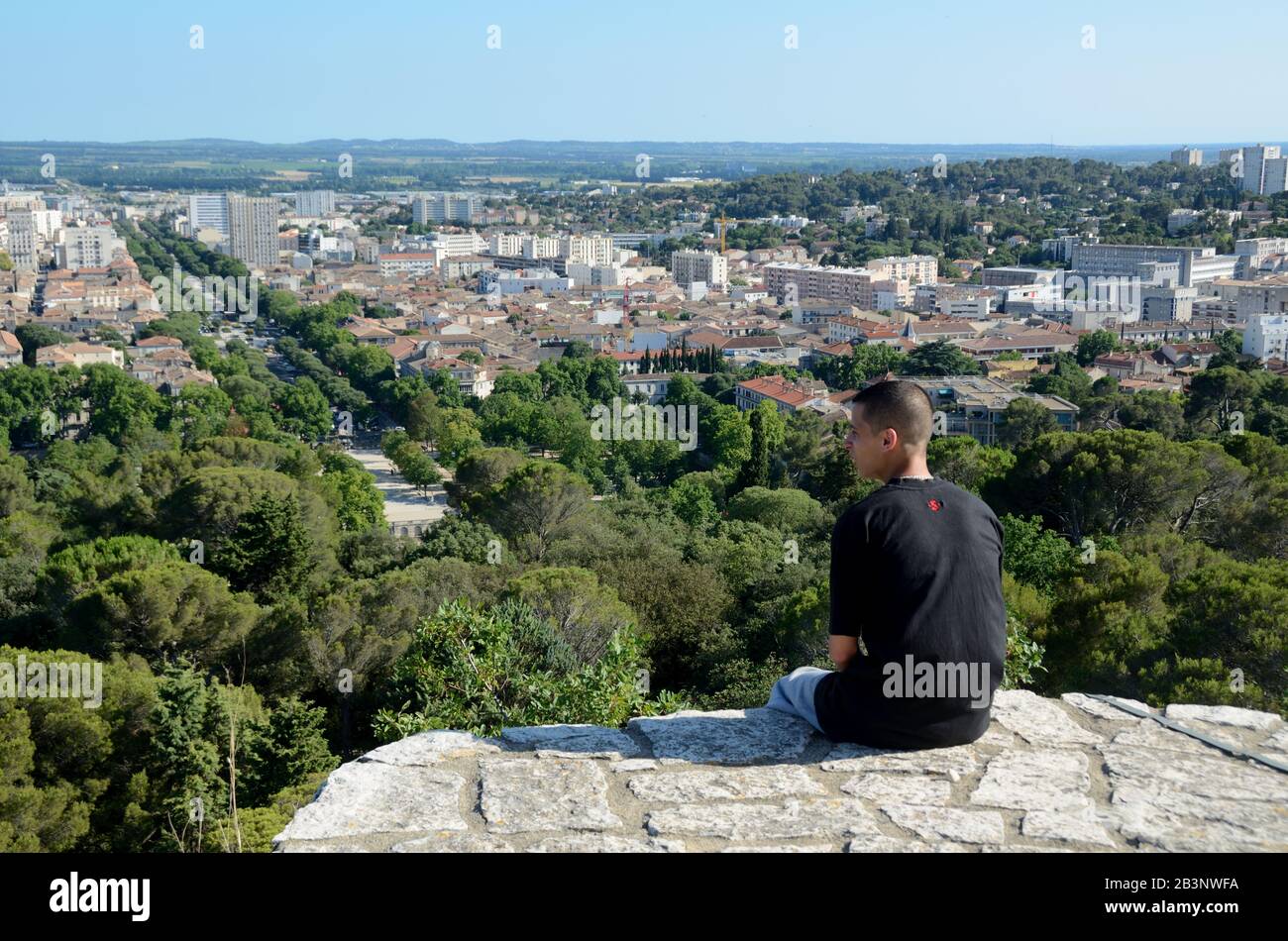 Junger Mann Mit Panoramablick über Nimes vom Römerturm oder Tour Magne mit der Avenue Jean Jaurès Nimes Gard France Stockfoto