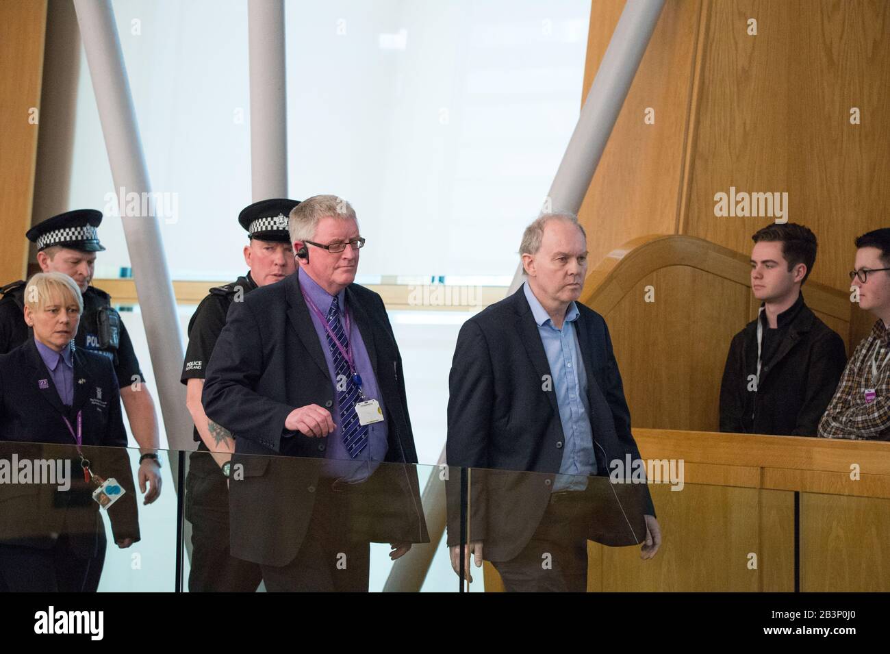 Edinburgh, Großbritannien. März 2020. Dargestellt: Ein Protestant wird am Ende der ersten Ministerfragen aus der Galerie in der Debattierkammer begleitet. Das Parlament wurde suspendiert, während das Protestor von der Polizei und der Sicherheit nach draußen begleitet wurde. Szenen aus ersten Ministerfragen im schottischen Parlament in Holyrood, Edinburgh. Kredit: Colin Fisher/Alamy Live News Stockfoto