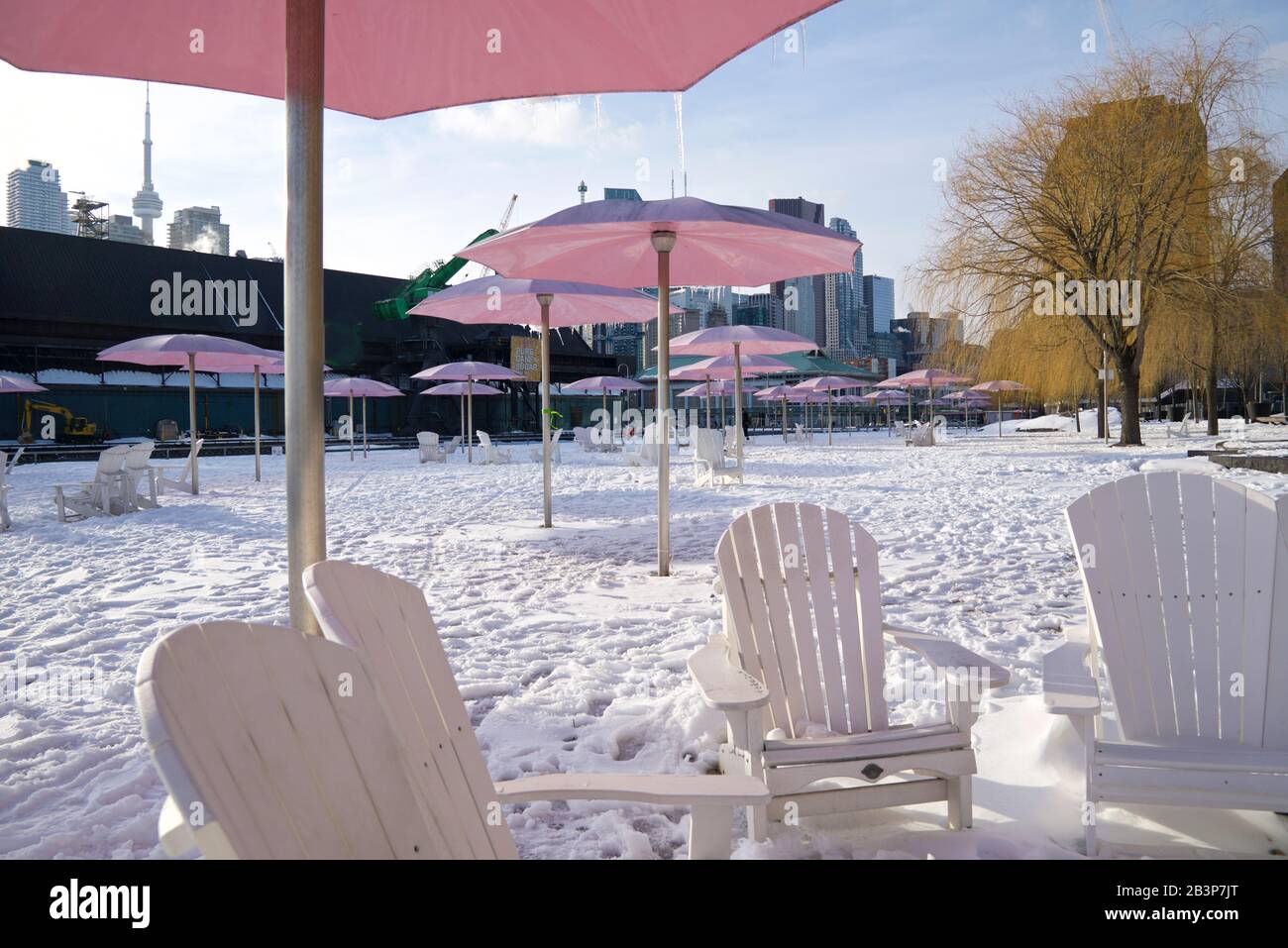 Schneebedeckte Liegestühle mit Sonnenschirmen in Lake Ontario Stockfoto