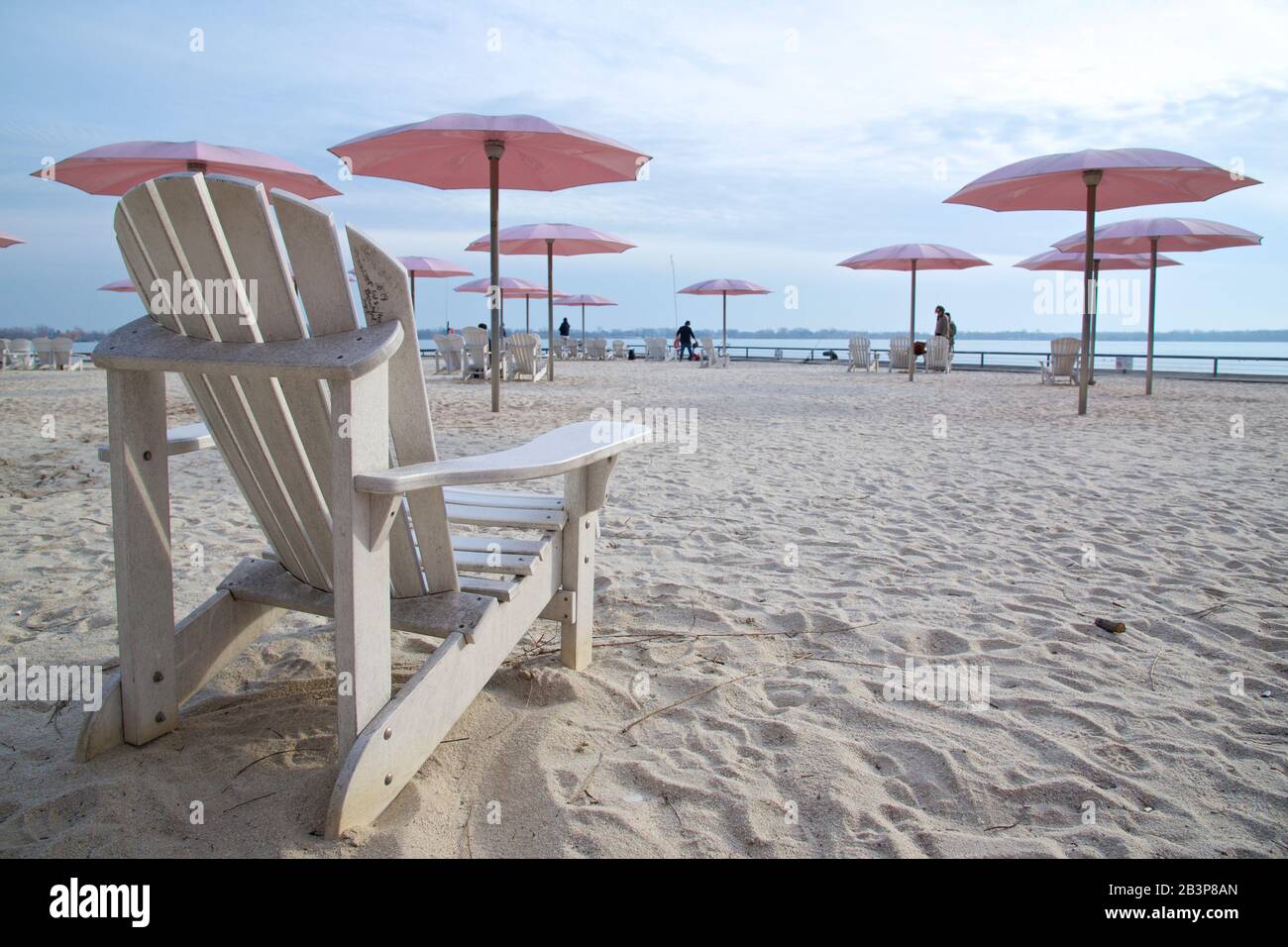 Liegestühle mit Sonnenschirmen am Sandstrand in Lake Ontario Stockfoto