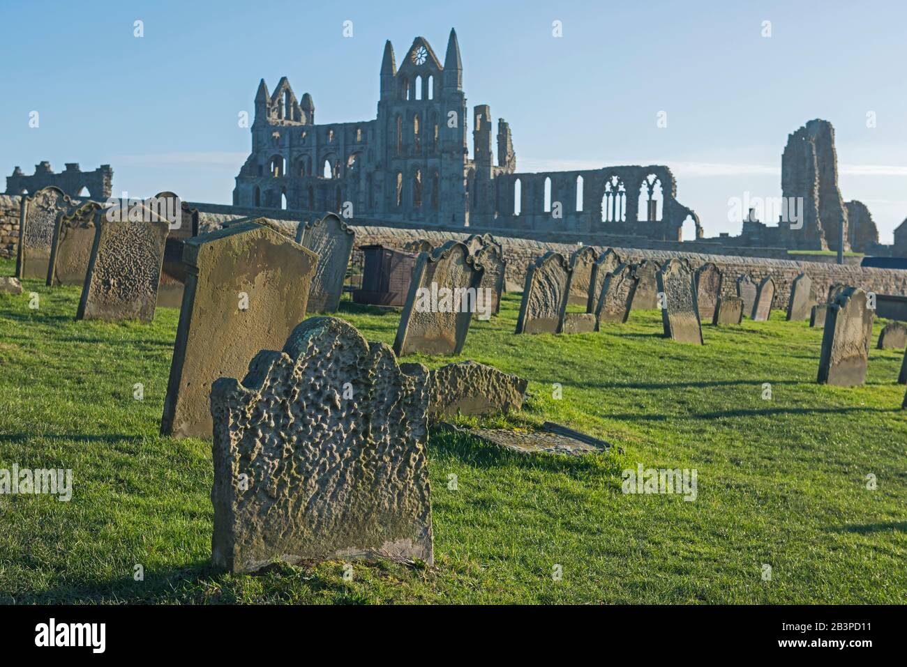 Überreste einer antiken englischen Abteiruine mit gotischer Architektur in ländlicher Landschaft und in Friedhöfen Stockfoto