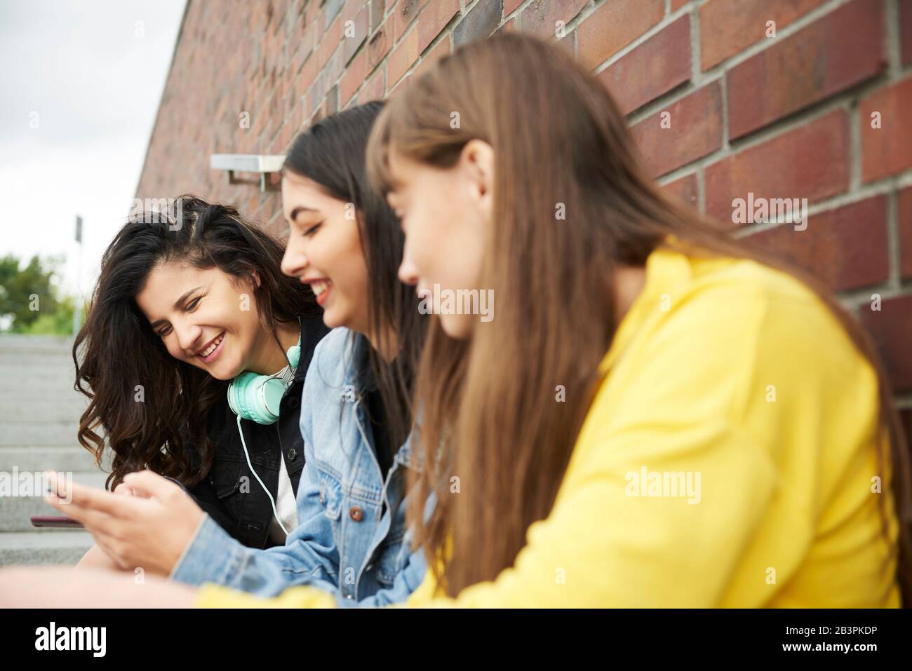 Treffen von drei jungen Frauen in der Stadt Stockfoto