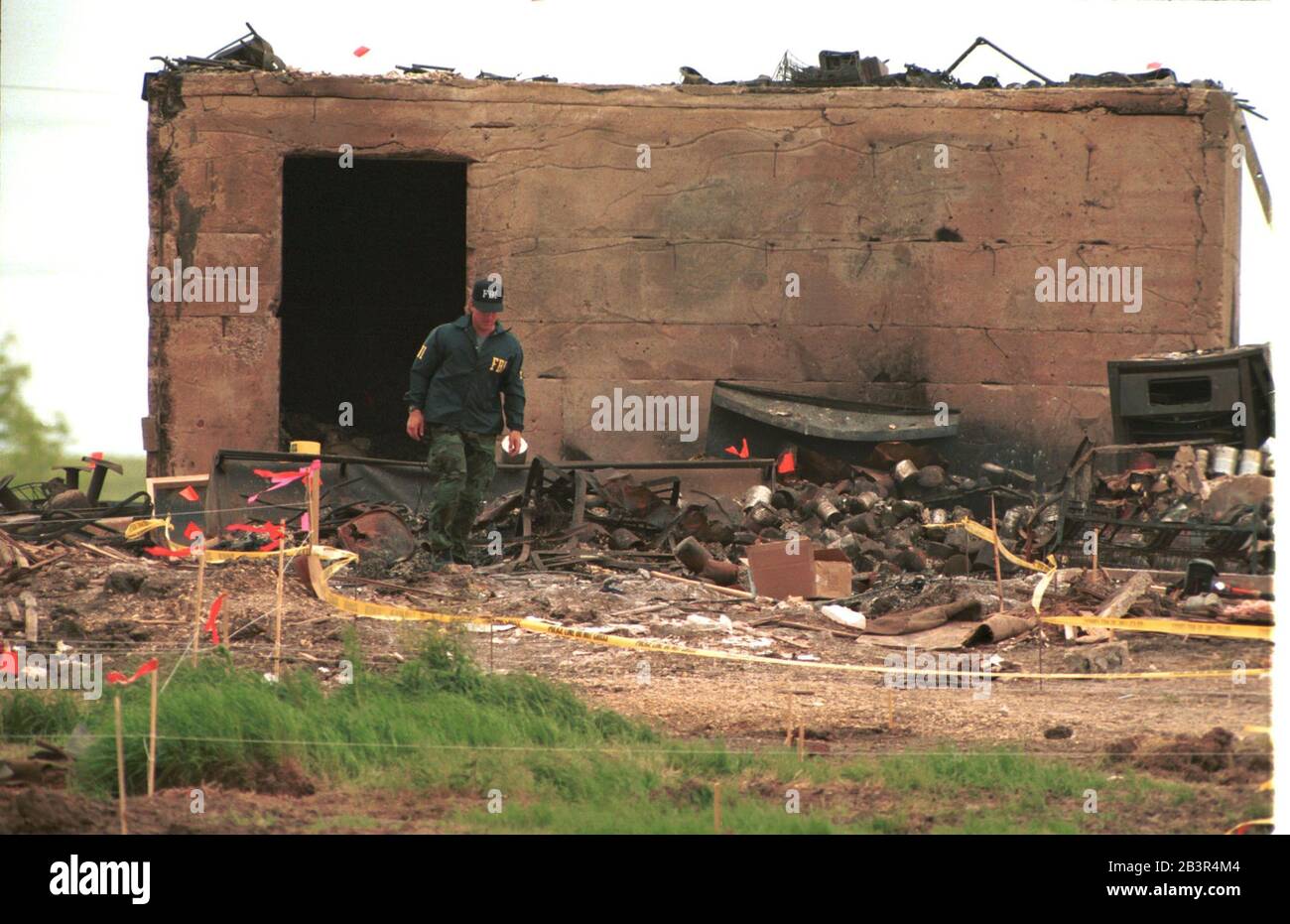 Waco Texas USA, 23 1993. April: Ein einsame FBI-Agent geht am verbrannten Munitionsbunker von Mt. Karmel nach dem Branch Davidian verbrannte vier Tage zuvor während der Belagerungszeit. ©Bob Daemmrich Stockfoto