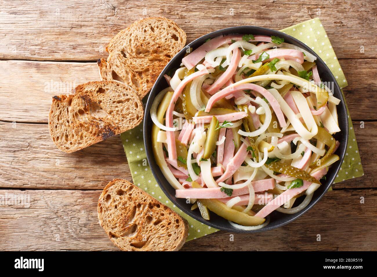 Servieren von Schweizer Wurstsalat in einem Teller auf dem Tisch horizontale Draufsicht von oben Stockfoto