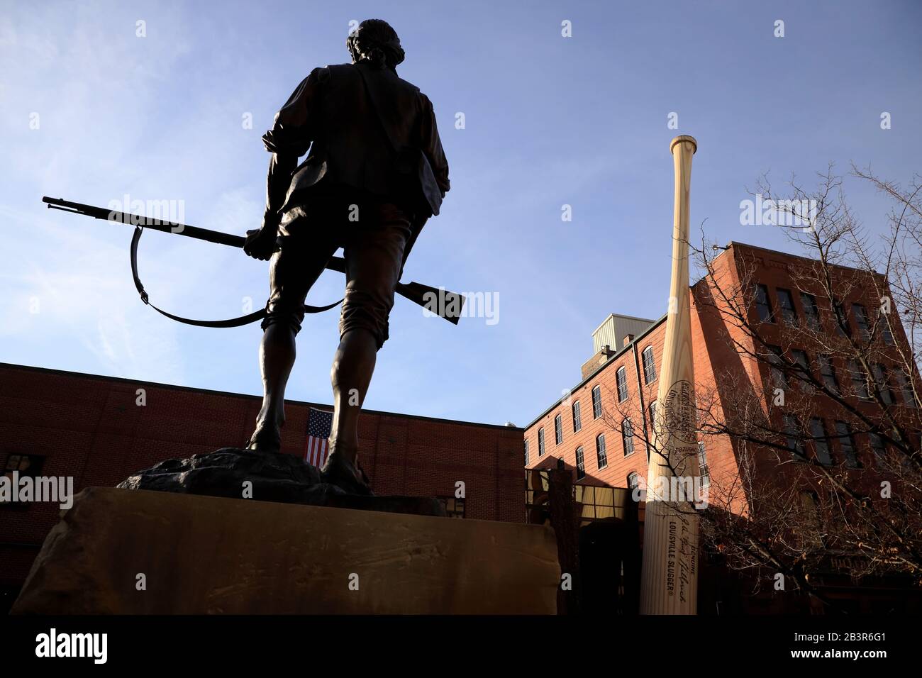 Die Statue der Söhne der Freiheit 1775 mit den Welten Größter Baseballschläger steht vor dem Louisville Slugger Museum & Fabrikgebäude im Hintergrund.Louisville.Kentucky.USA Stockfoto