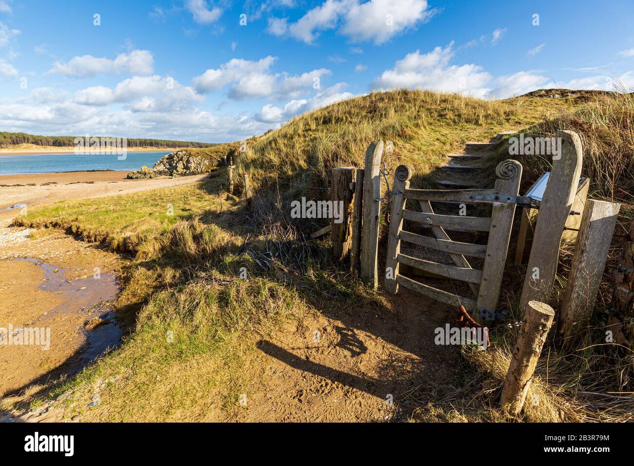 Ein geschnitztes Eingangstor zur Insel Llanddwyn mit Newborough Beach im Hintergrund, Anglesey Stockfoto