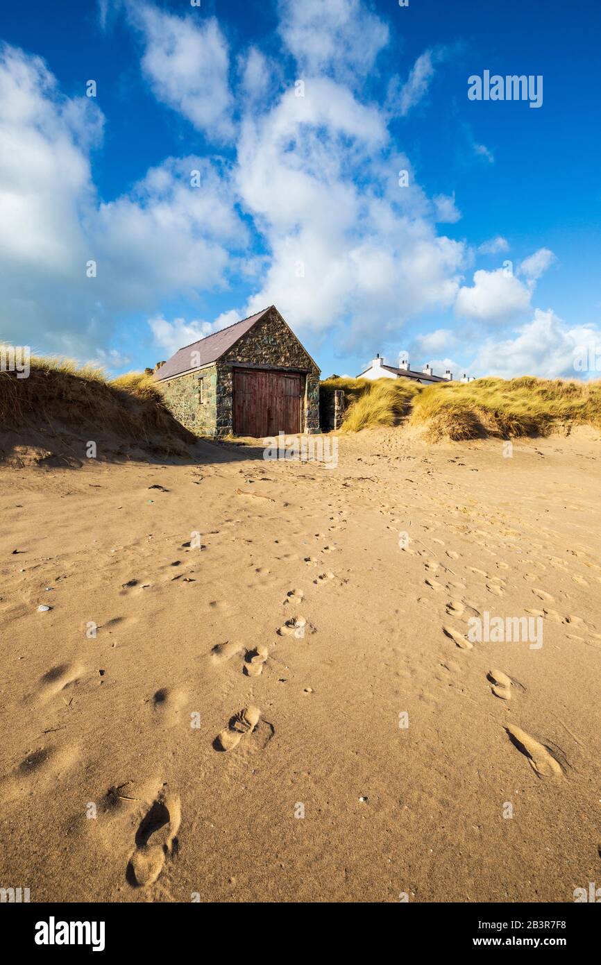 Das Rettungsschwimmhaus und die Dächer der weißen Cottages des Piloten vom Strand auf der Insel Llanddwyn, Anglesey Stockfoto