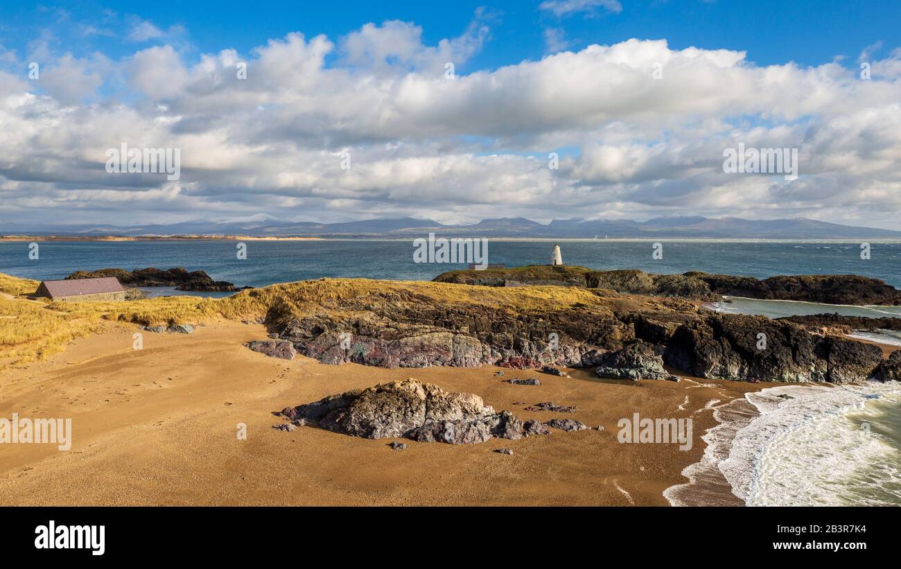 Ein Blick auf Twr Bach und die schneebedeckten Snowdonia Berge über Porth Twr Mawr auf Llanddwyn Island, Anglesey Stockfoto
