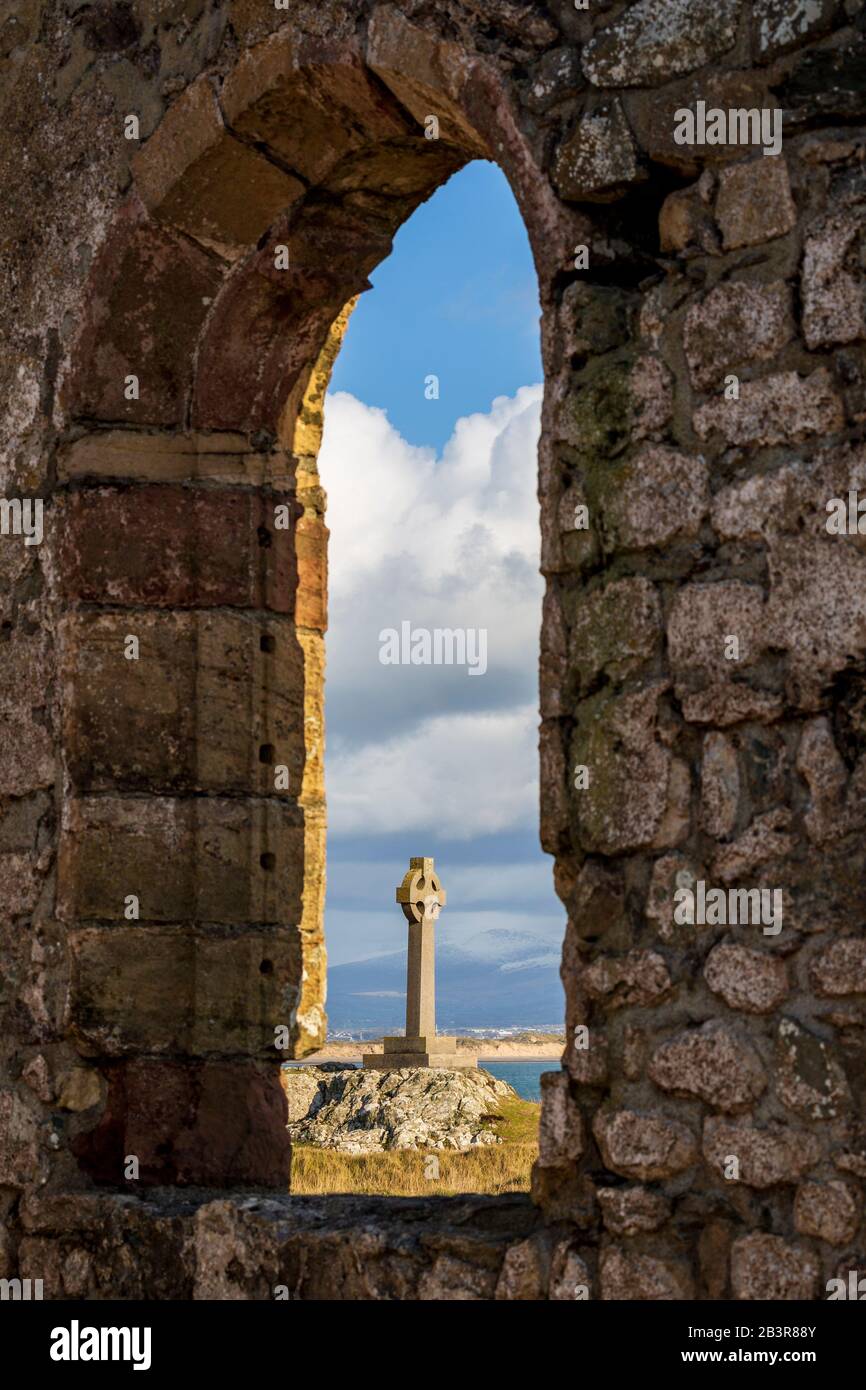 Das Keltenkreuz hat einen Blick durch die Ruinen von St Dwynwens Kirche auf der Insel Llanddwyn, Anglesey Stockfoto