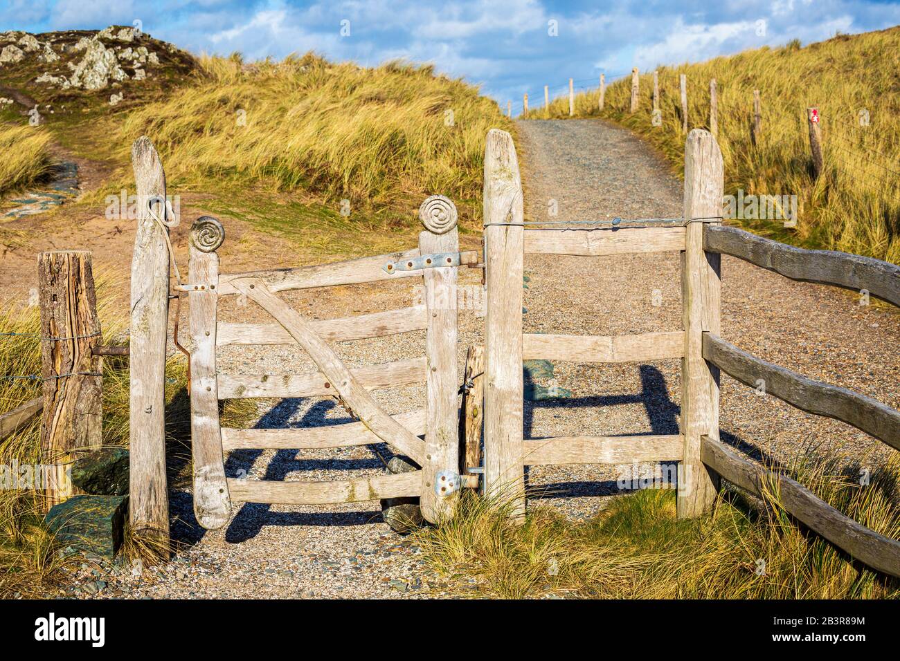Ein geschnitztes Holztor und eine Stiele auf der Insel Llanddwyn, Anglesey Stockfoto