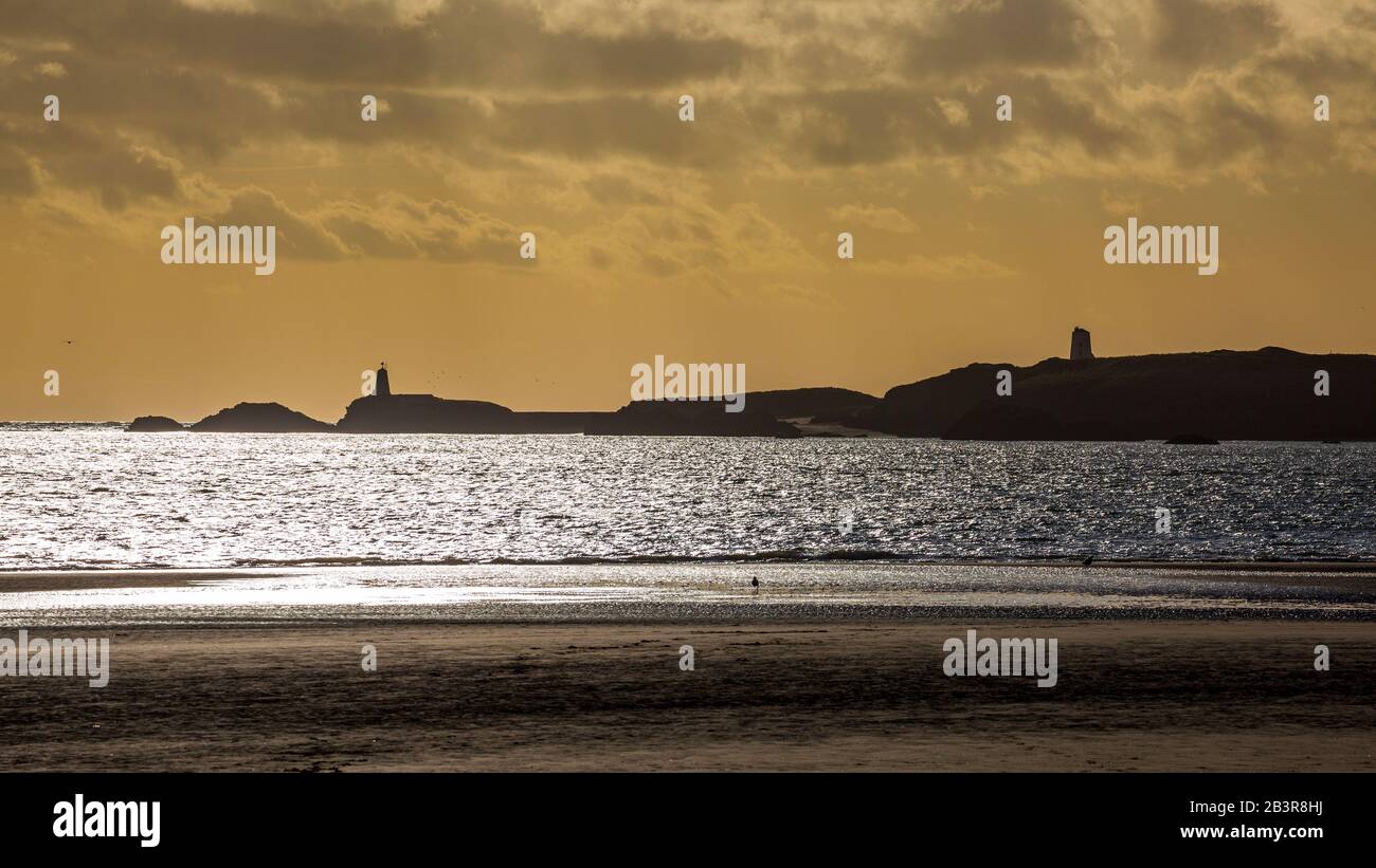 Eine Silhouette der Insel Llanddwyn und der Leuchttürme von Twy Bach und Twr Mawr vom Strand von Newborough, Anglesey Stockfoto