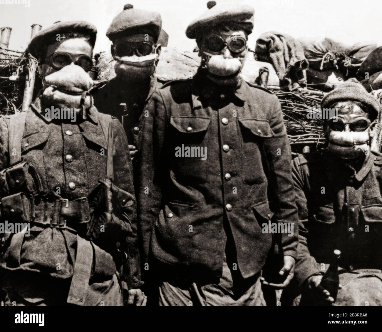 Männer der Argyll und Sutherland Highlanders tragen frühe Polsteratrespiratoren. Der Erste Weltkrieg brachte den ersten Bedarf an massenproduzierten Gasmasken auf beiden Seiten wegen des umfangreichen Einsatzes von Chemiewaffen. Die deutsche Armee setzte bei der Zweiten Schlacht von Ypern, Belgien am 22. April 1915 erstmals Giftgas gegen alliierte Truppen ein. Als unmittelbare Reaktion wurde bis zum 1. Mai in Muslin verpackte Baumwollwolle an die Truppen ausgegeben. Darauf folgte der Black Veil Respirator, ein mit einer saugfähigen Lösung getränktes Baumwollpolster, das mit schwarzem Baumwollverschleiß über den Mund gesichert wurde. Stockfoto