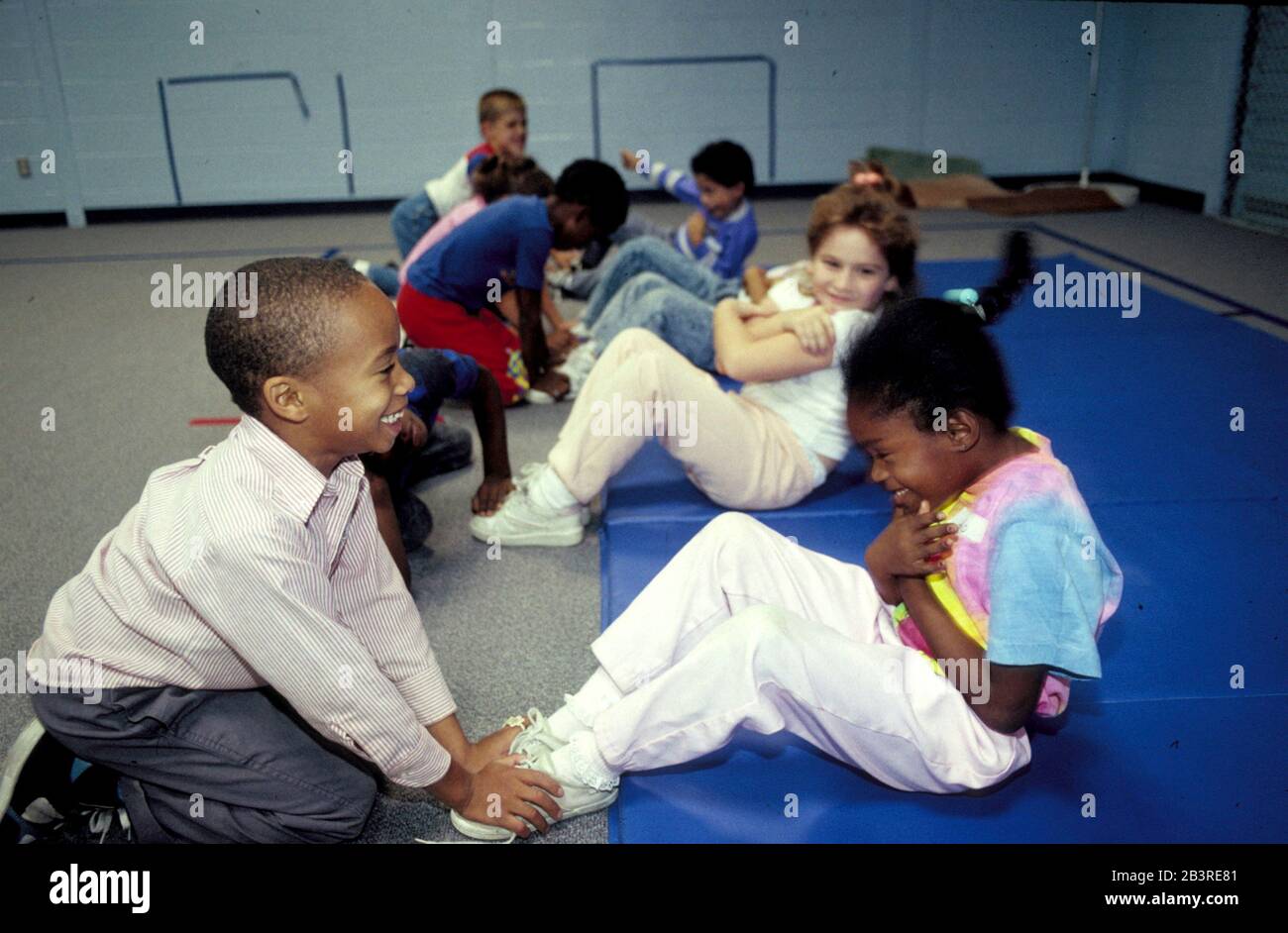 Austin Texas USA: Grundschüler machen situps während der körperlichen Bildung in der Schulhalle. ©Bob Daemmrich Stockfoto