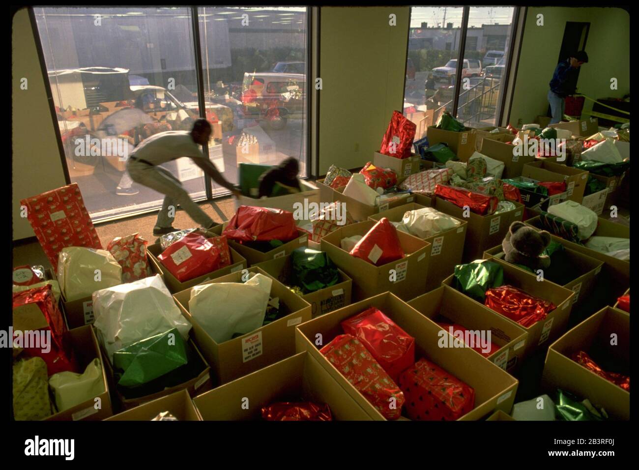Austin, Texas, USA, um 1982: Freiwilliger hilft bei der Vorbereitung von Spielzeug für die Verteilung an Kinder mit geringem Einkommen im Rahmen des Weihnachtsprogramms der Polizeibehörde von Austin, „Blauer Weihnachtsmann“. ©Bob Daemmrich Stockfoto