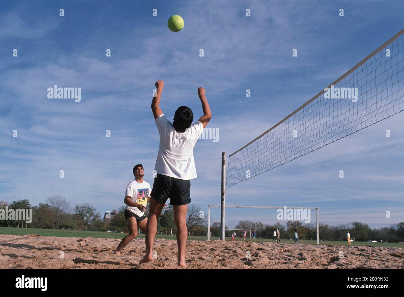 Junge Männer spielen Sandvolleyball im Zilker Park in Austin, Texas Stockfoto