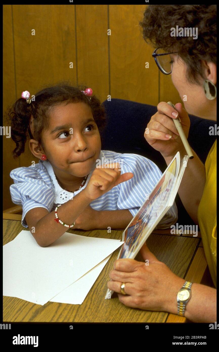 Austin Texas USA, um 1991: Der Sprachtherapeut einer öffentlichen Schule nutzt Bildband, um Antworten des 6-jährigen Hispanic während einer Einzeltherapie zu erhalten. ©Bob Daemmrich Stockfoto