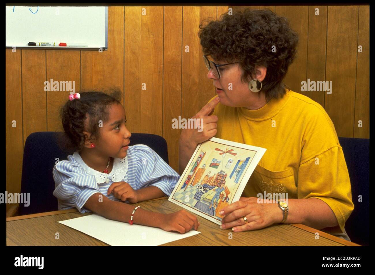 Austin Texas USA, um 1991: Der Sprachtherapeut einer öffentlichen Schule nutzt Bildband, um Antworten des 6-jährigen Hispanic während einer Einzeltherapie zu erhalten. ©Bob Daemmrich Stockfoto