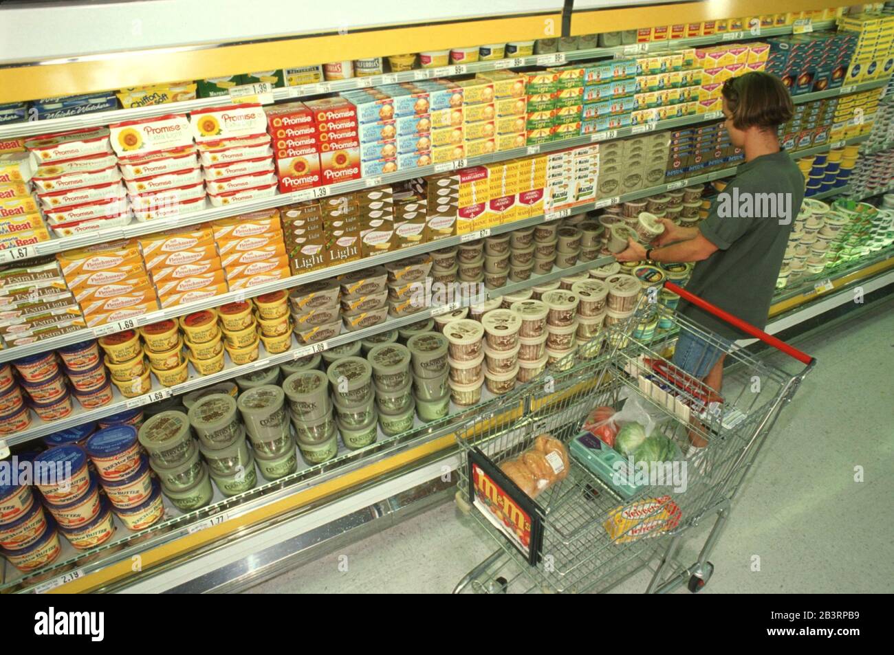 Austin Texas USA, um 1990: Frau mit Einkaufswagen sieht sich Produkte auf dem Milchgang des Supermarkts an. Stockfoto