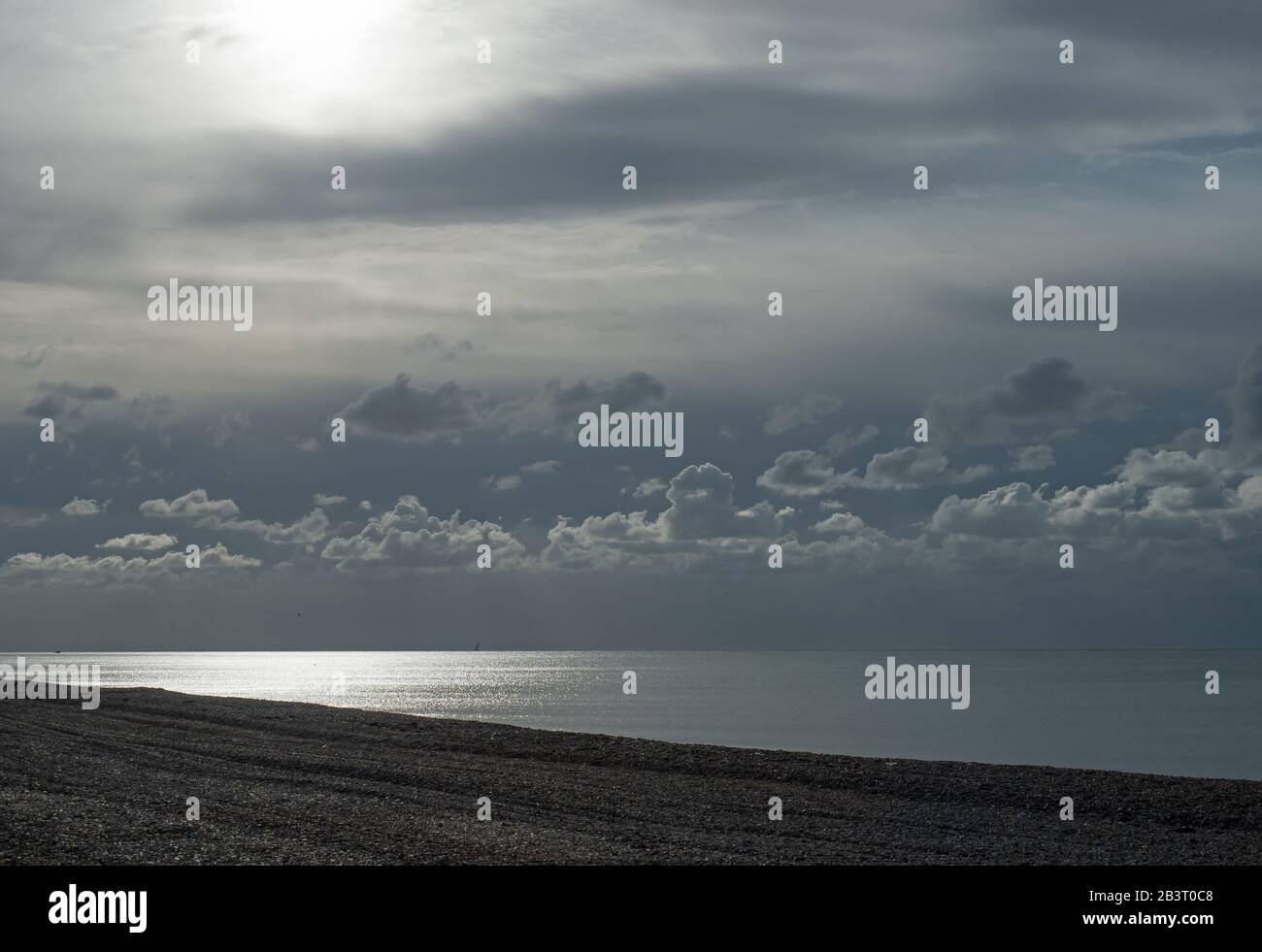 Wolkenschichten über dem Meer in Seaford in East Sussex, wobei schwaches Sonnenlicht durchbricht. Stockfoto