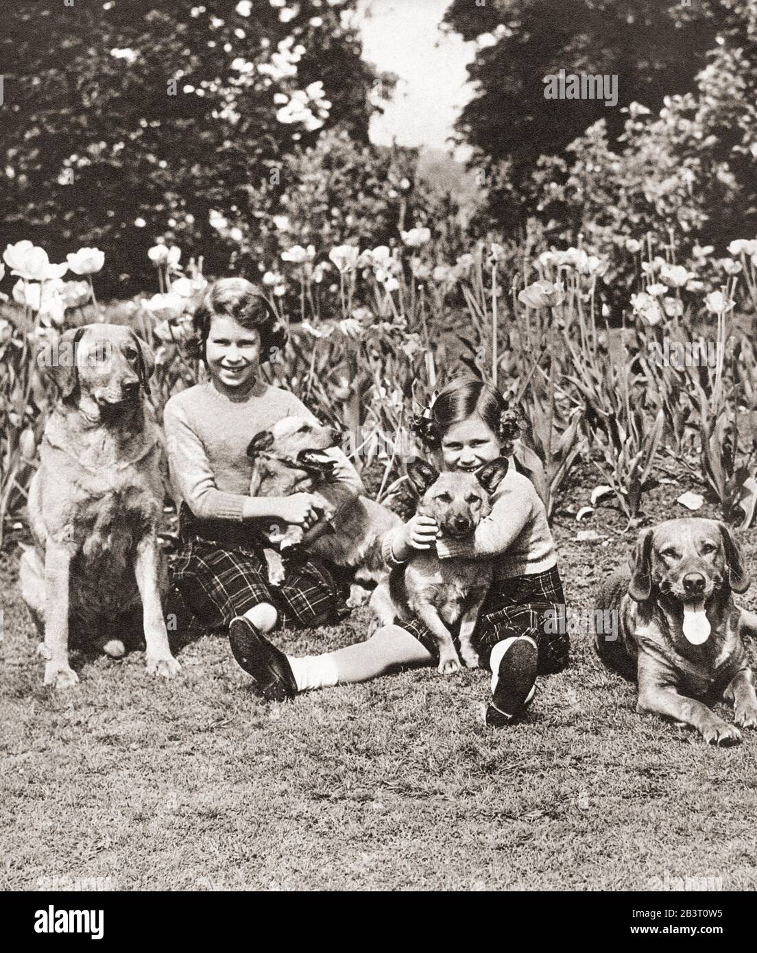 Prinzessin Elizabeth, links, und Prinzessin Margaret mit ihren Haustieren, Royal Lodge, Windsor, England. Prinzessin Elizabeth von York zukünftige Elizabeth II, 1926 - 2022. Königin des Vereinigten Königreichs. Prinzessin Margaret Rose, zukünftige Gräfin von Snowden, 1930 – 2002. Jüngere Tochter von König George VI und Königin Elizabeth des Vereinigten Königreichs und Schwester von Königin Elizabeth II.. Aus dem Krönungsbuch, erschienen 1937. Stockfoto