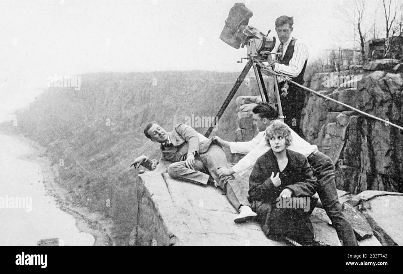 Pearl WHITE (1889-1938) amerikanische Bühne und Stummfilmschauspielerin vor Ort am Cliffhanger Point auf den Hudson Palisades für die Serie The House of Hate von 1918 mit Co-Star Antonio Moreno an der Klippe Stockfoto