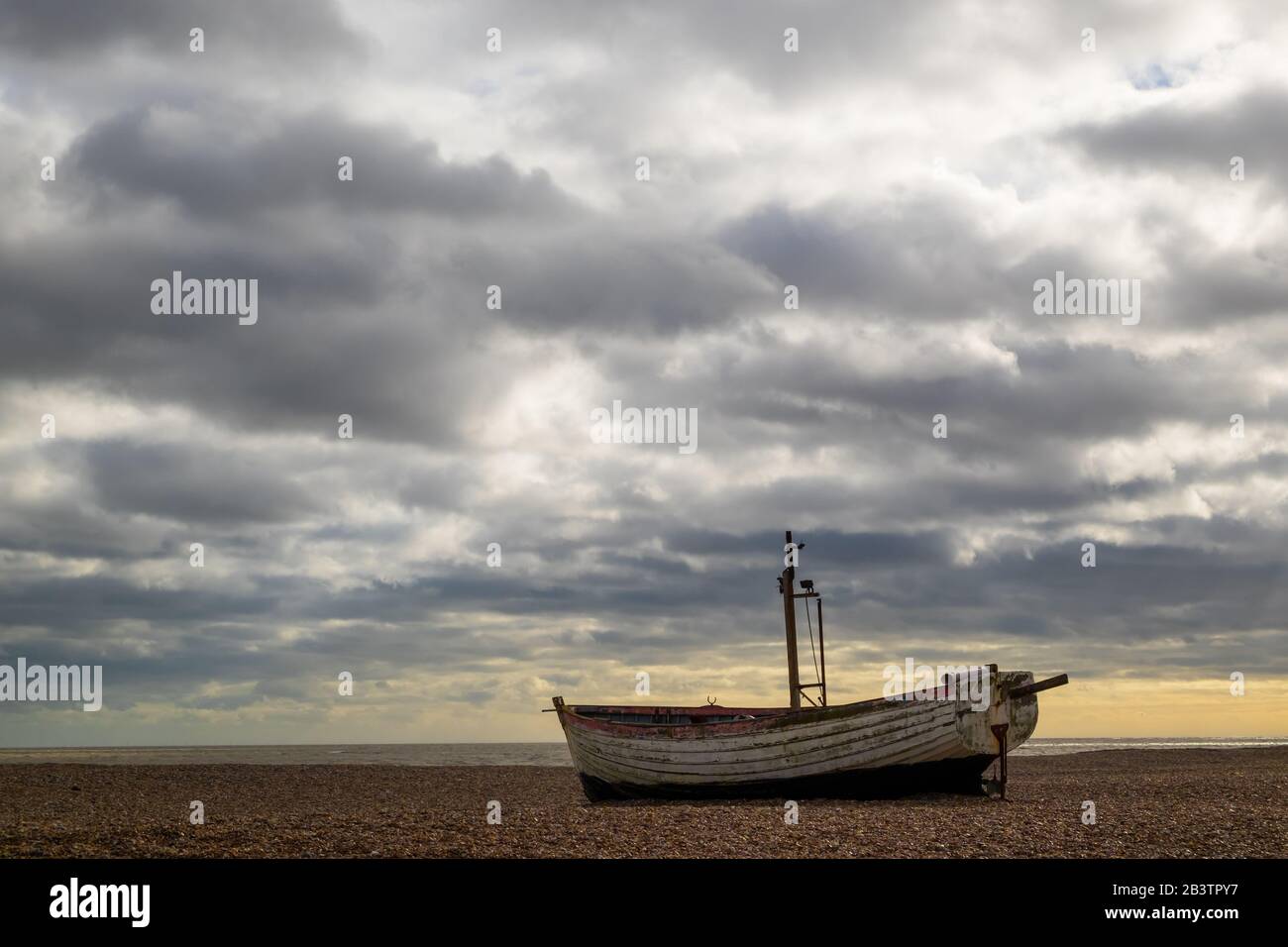 Altes verlassene Fischerboot mit dramatischem Himmel auf Aldeburgh Beach, Aldeburgh, Suffolk. GROSSBRITANNIEN Stockfoto
