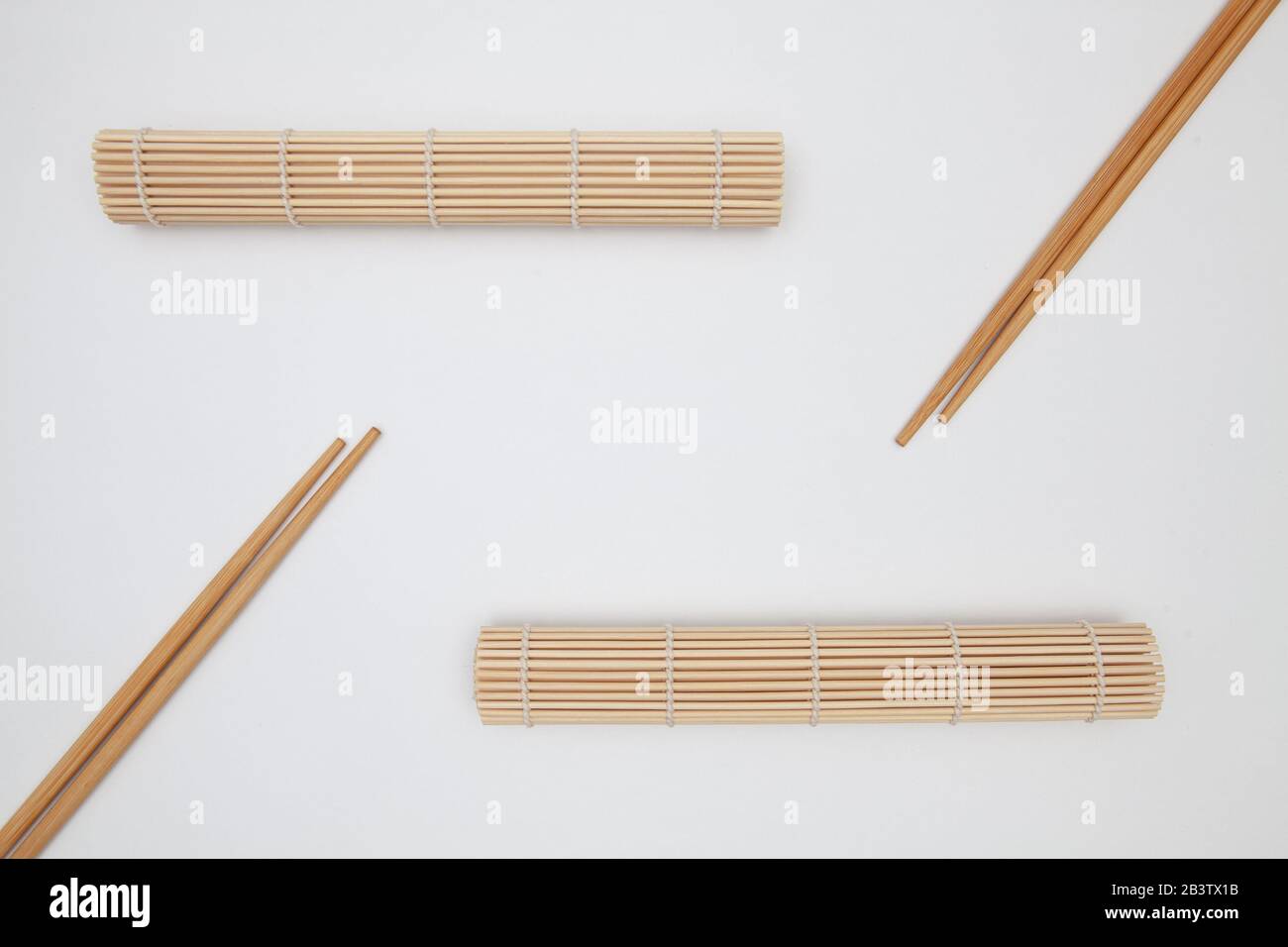 Bambusmatte mit Essstäbchen für Sushi auf dem weißen Tisch. Lebensmitteldesign Stockfoto