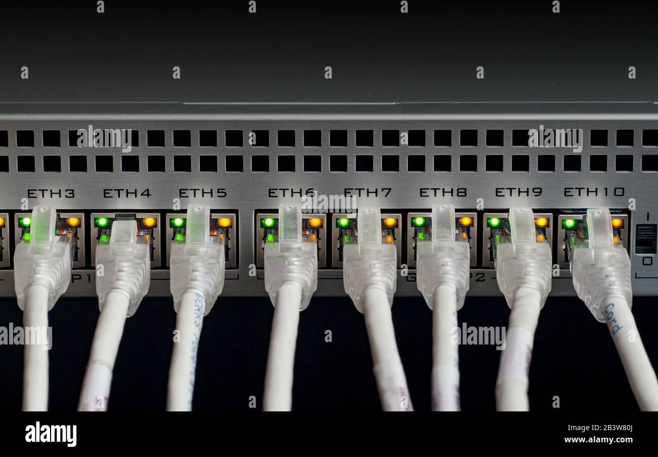 Weißes Netzwerkkabel mit einem Switch verbunden. Selektiver Fokus Stockfoto