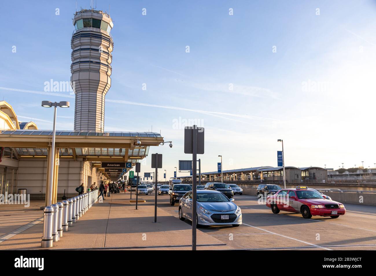 Ronald Reagan Washington National Airport Terminal B/C am geschäftigen, sonnigen Nachmittag mit Air Traffic Control Tower im Hintergrund gesehen. Stockfoto