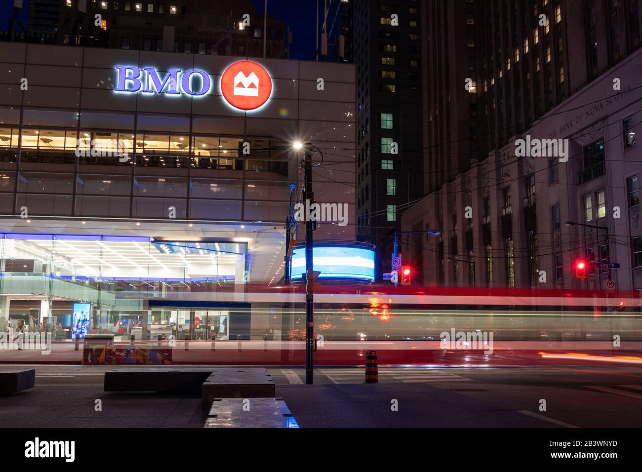 Bank of Montreal (BMO) Zeichen oben auf ihrer Niederlassung am Fuße des ersten kanadischen Platz an einem geschäftigen in der Nacht in der Innenstadt von Toronto. Stockfoto