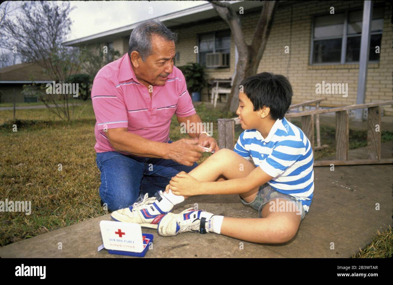 Austin Texas USA: Der Urgroßvater der USA neigt dazu, das Knie des Enkels zu verletzen. ©Bob Daemmrich Stockfoto