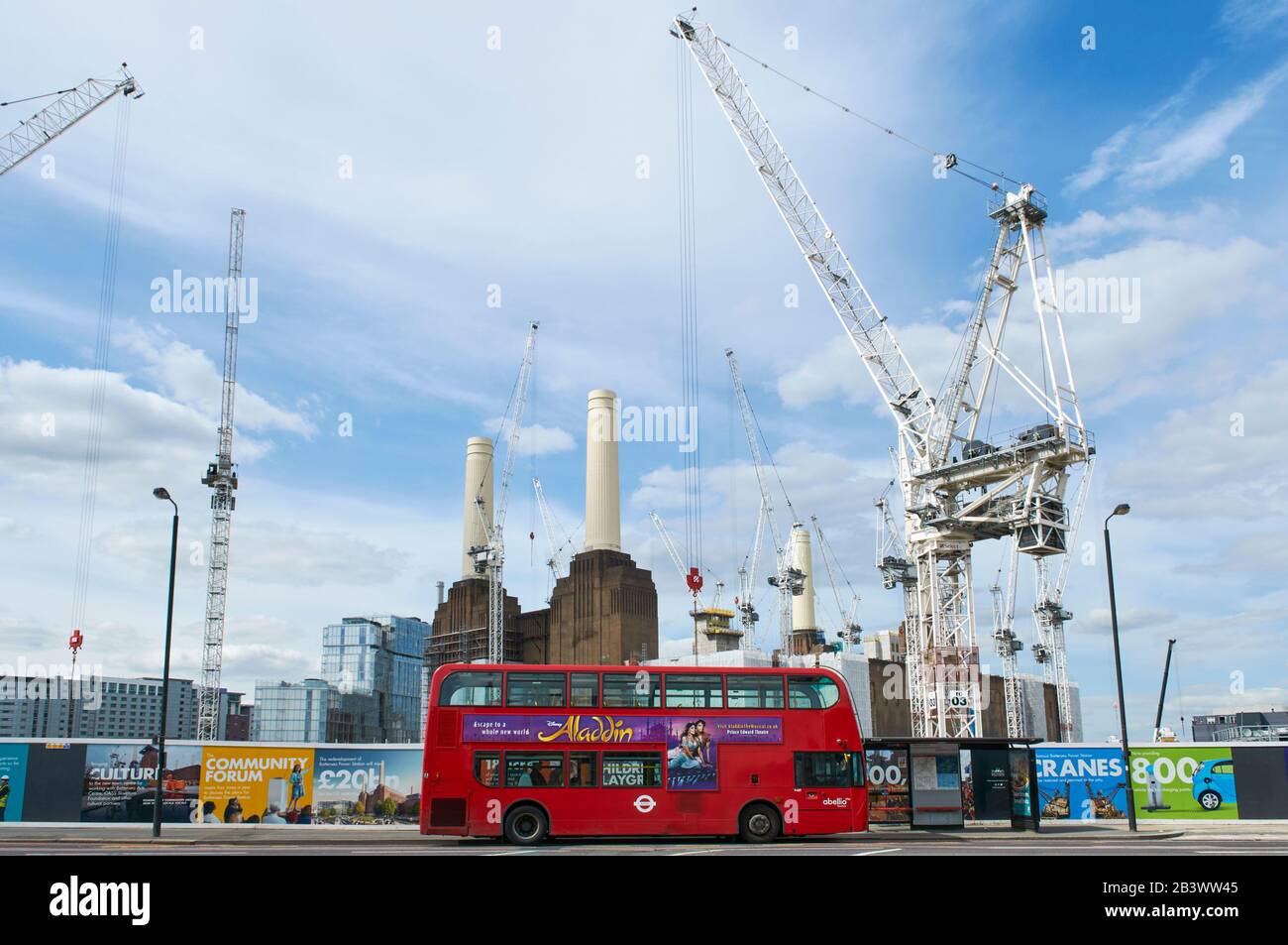 Battersea Park Road, South London UK, mit rotem Bus und Battersea Power Station, die im Hintergrund umgebaut wird Stockfoto