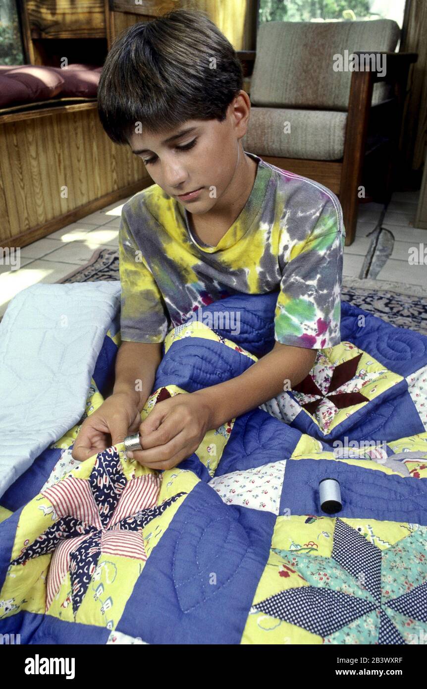 Austin Texas USA: Hispanischer Junge, der eine Nadel, einen Faden und ein Flint verwendet, während er einen Quilt zusammenstellt. ©Bob Daemmrich Stockfoto