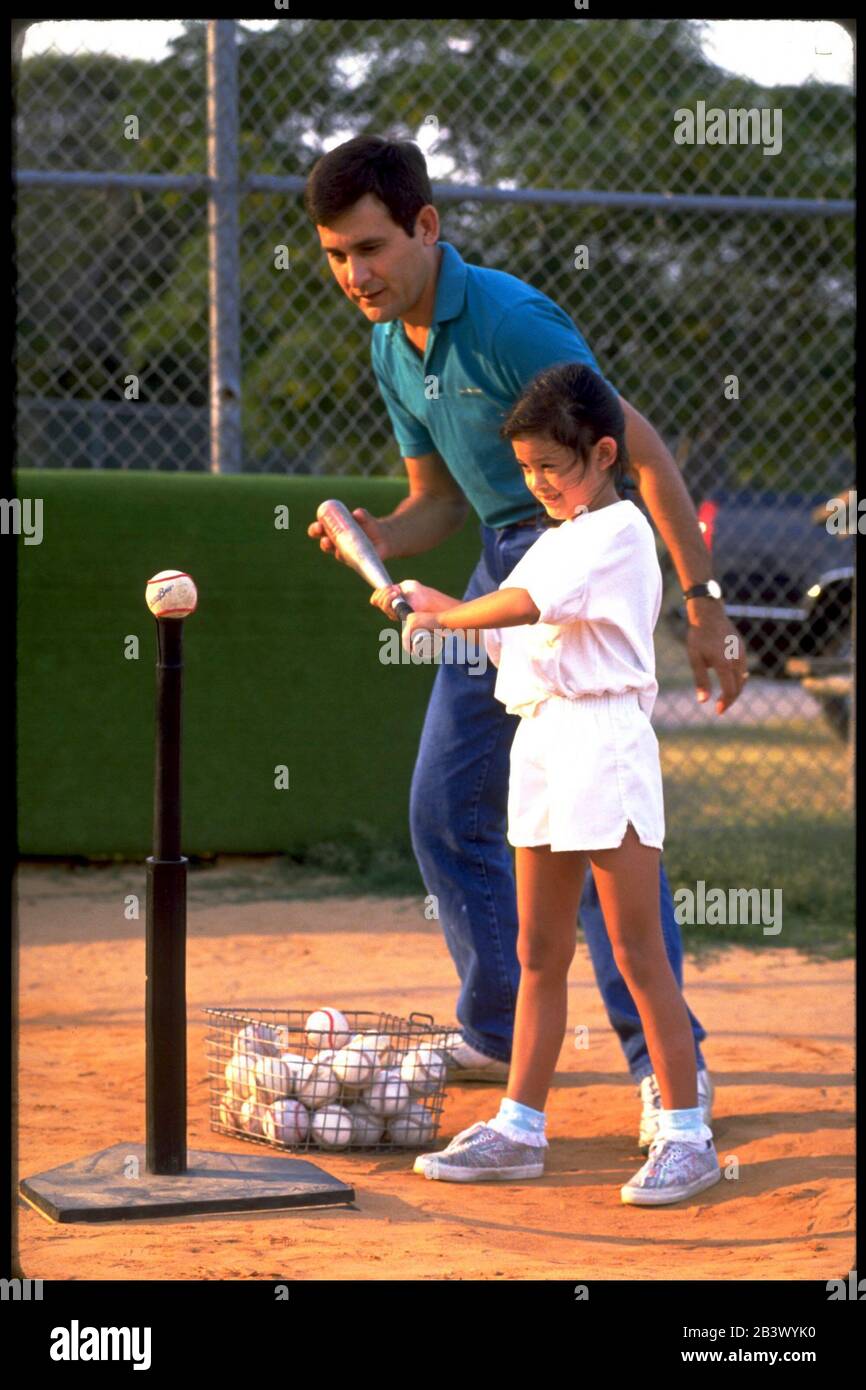 Austin Texas USA: Hispanischer Vater trainiert seine Tochter in T-Ball. ©Bob Daemmrich Stockfoto